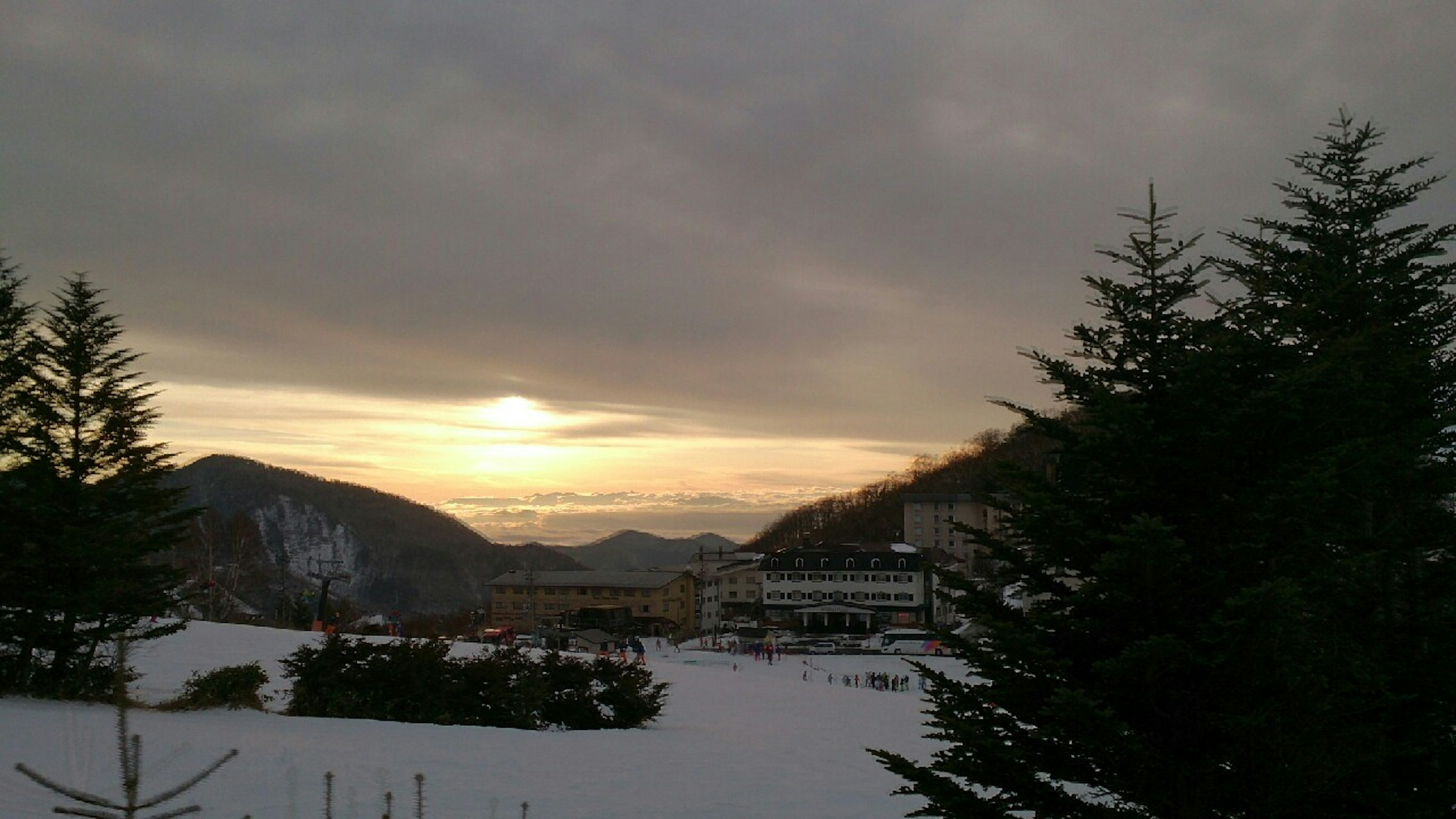 Paysage enneigé avec des montagnes et un soleil couchant