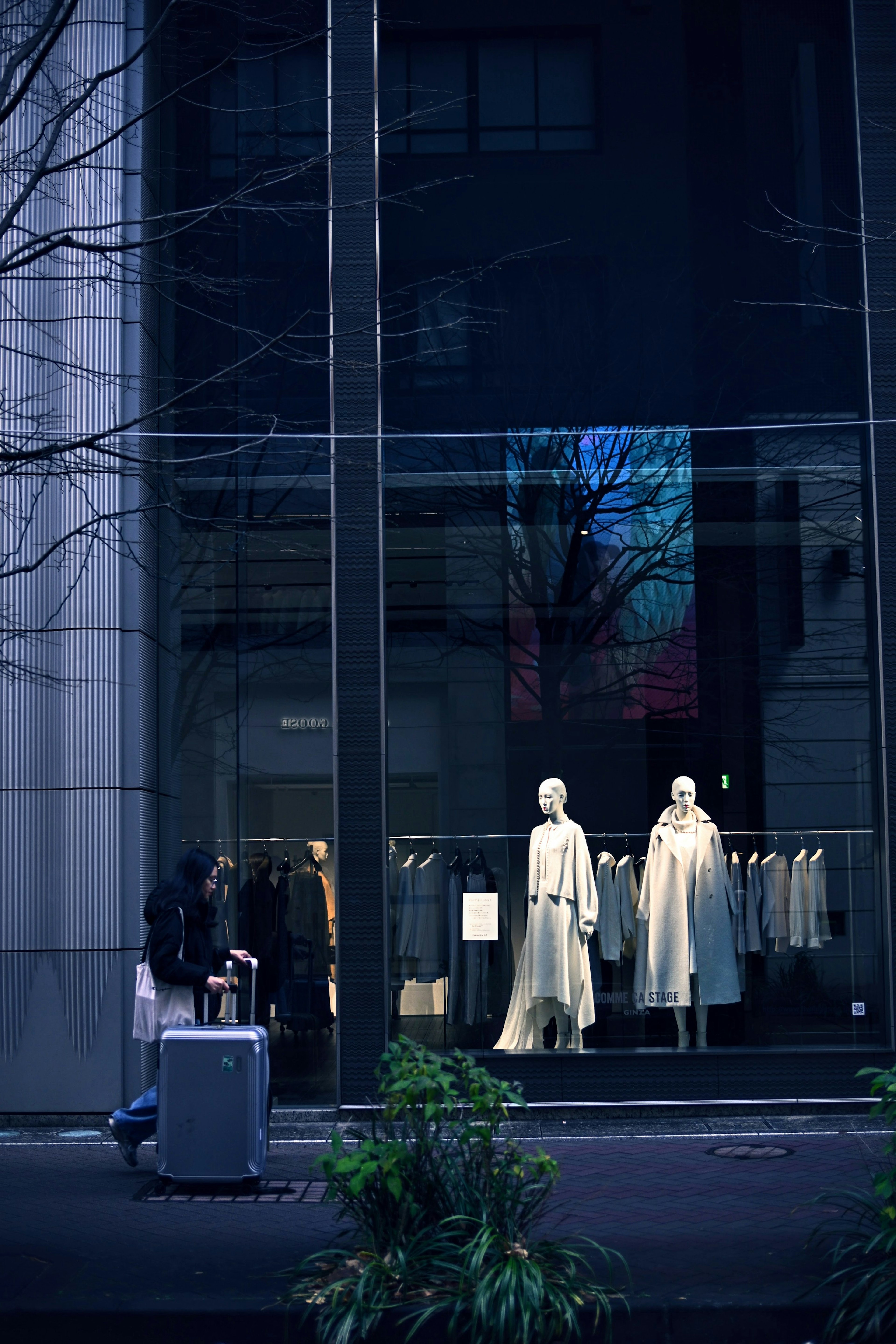 Vitrine de magasin de mode affichant des vêtements blancs avec vue sur la rue