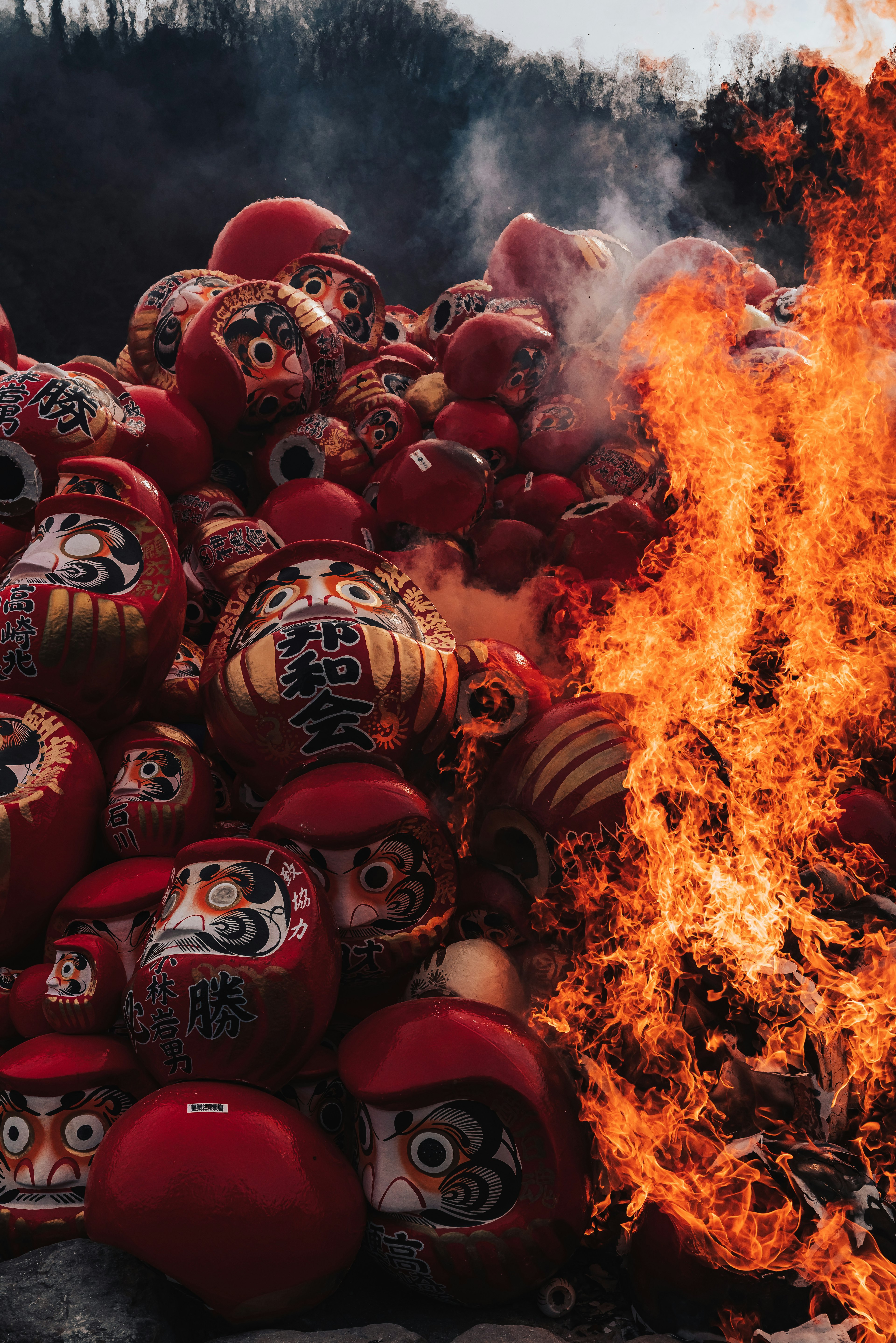 Contraste entre les poupées daruma en feu et les flammes