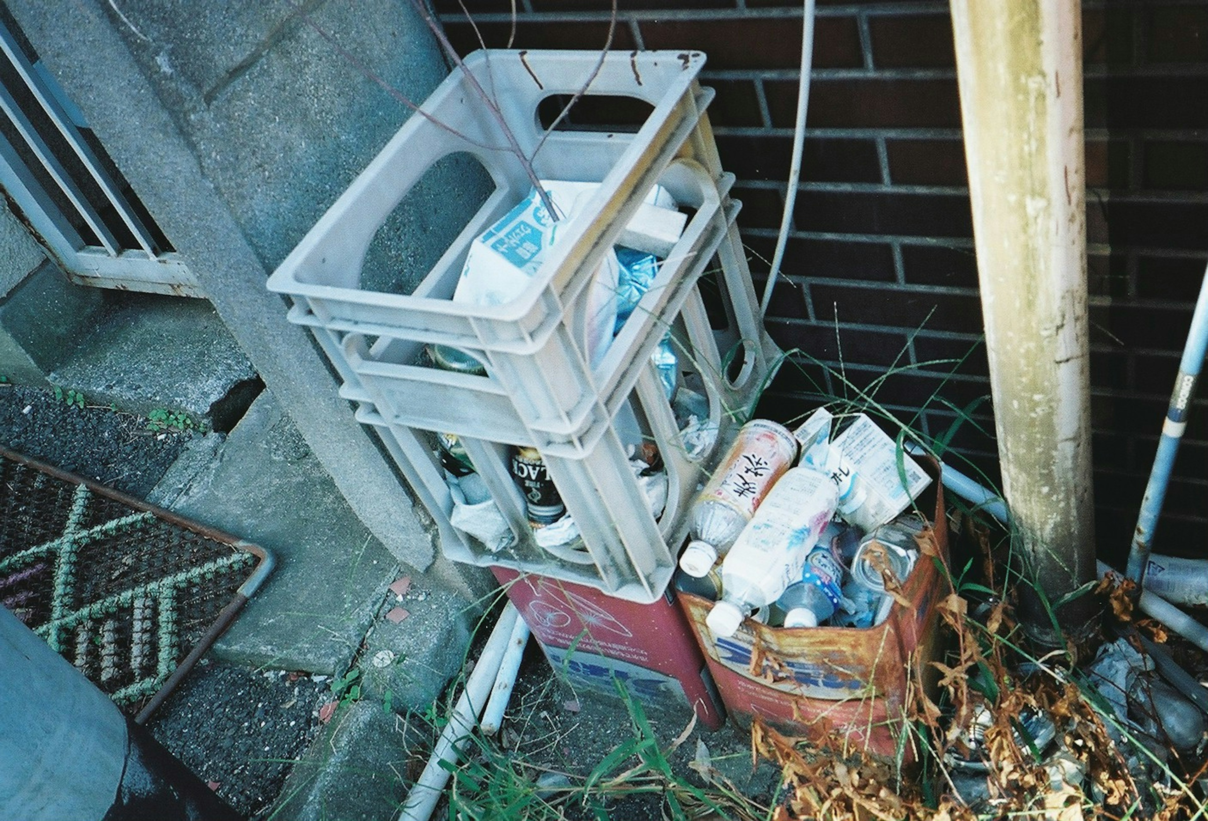 Stack of plastic crates filled with trash near a wall