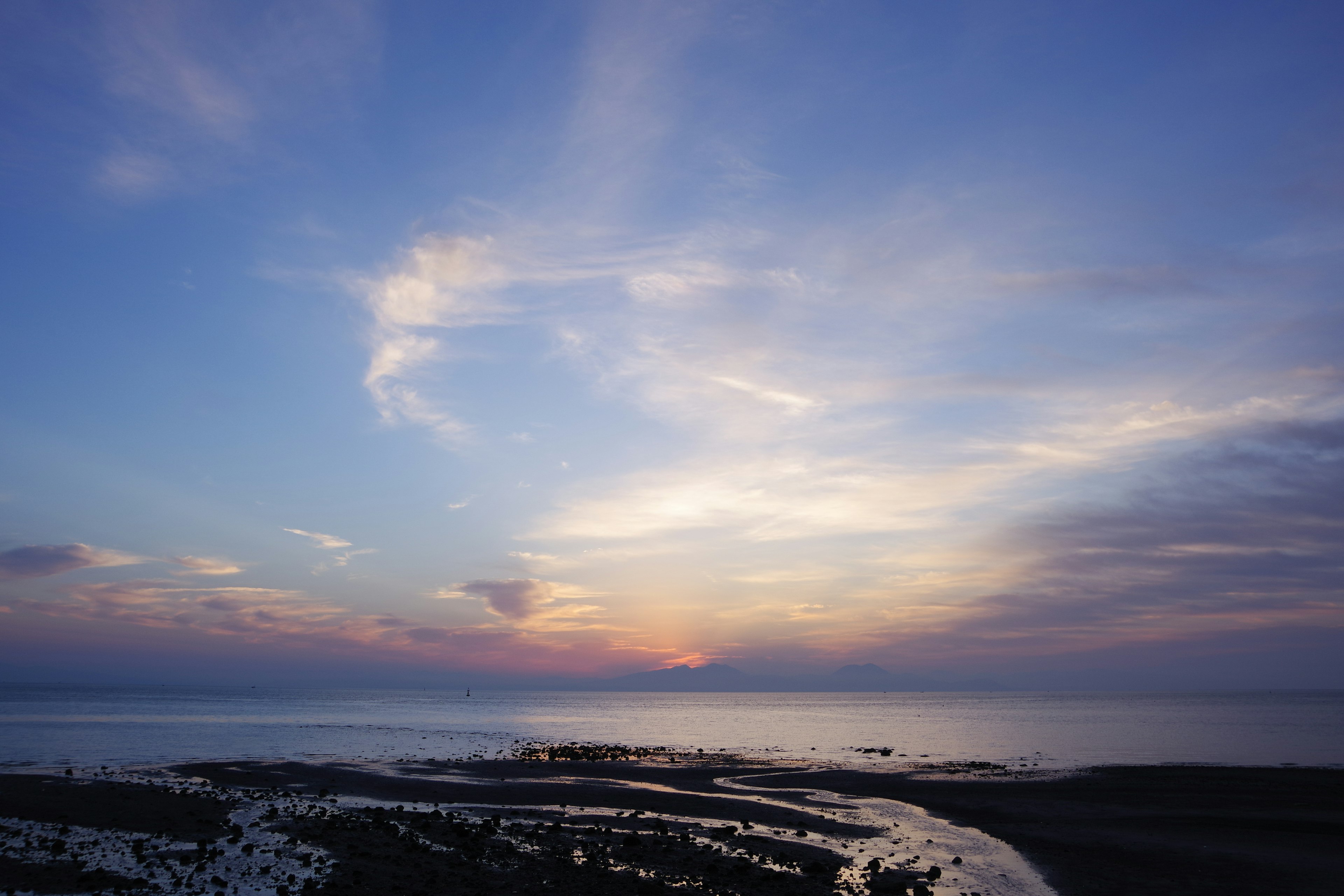 Hermoso atardecer sobre el mar cielo azul con nubes esponjosas