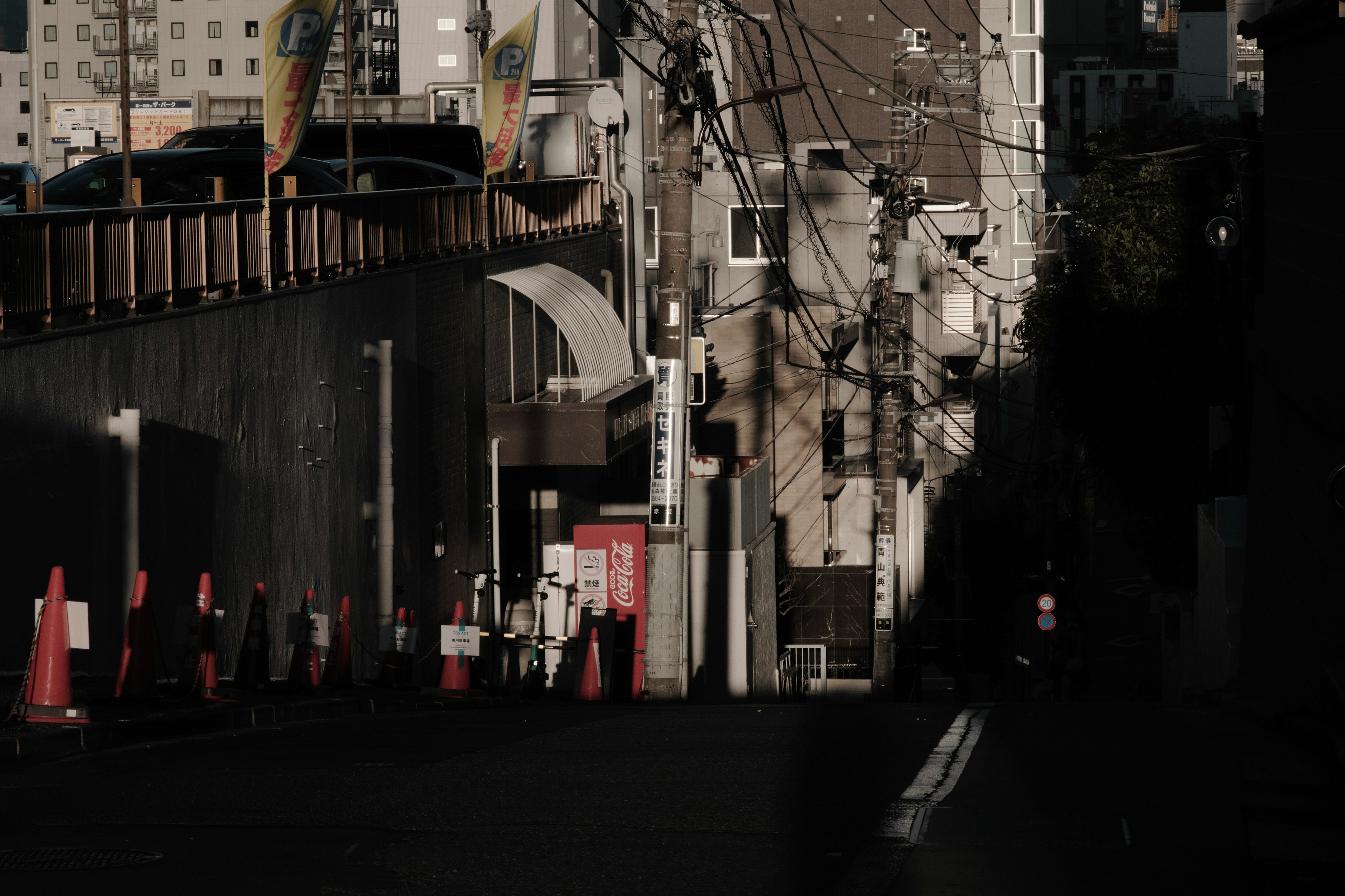 暗い街路に立つ人々と電柱が映る都市風景