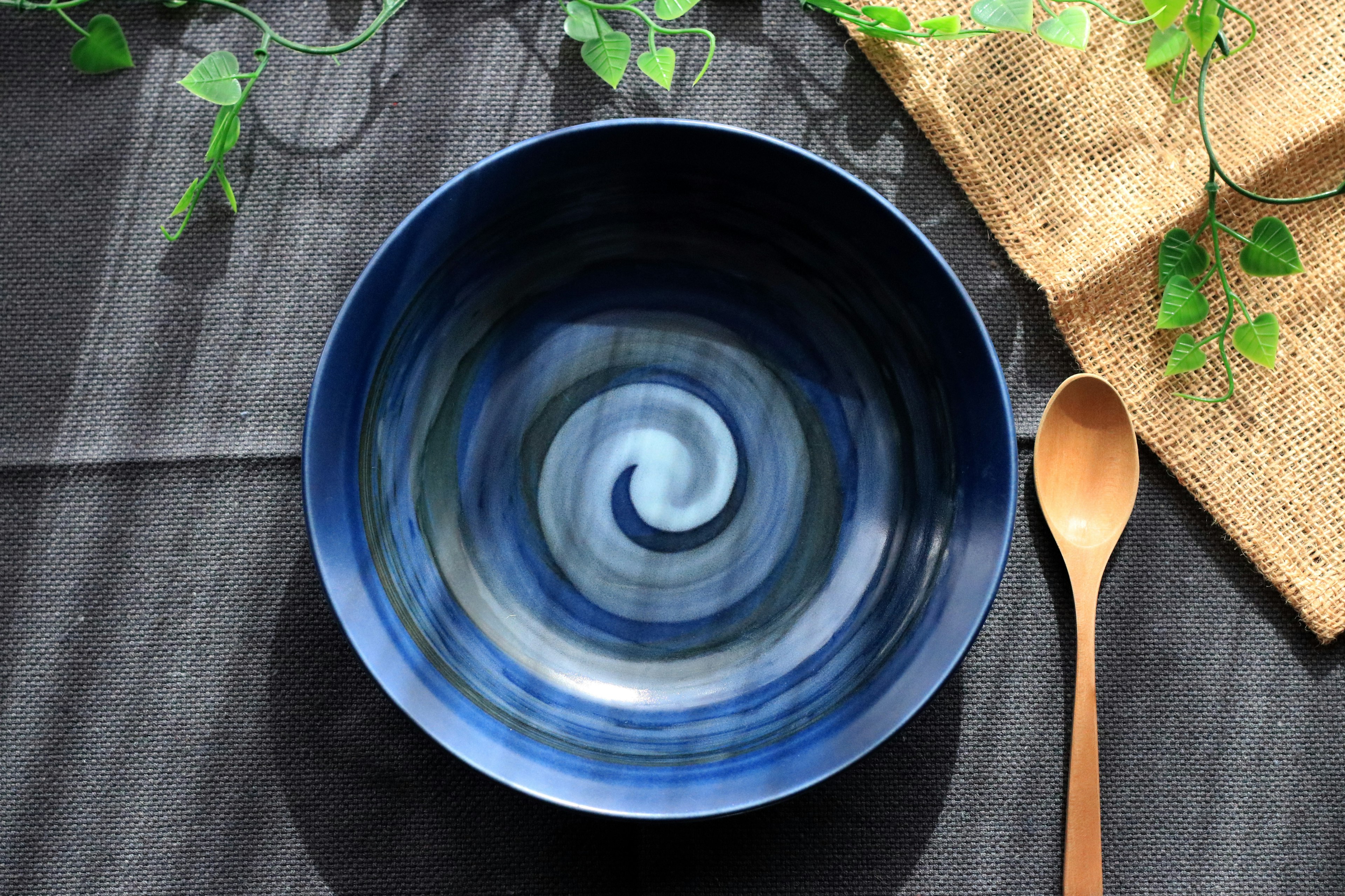 Image of a blue swirl patterned bowl with a wooden spoon