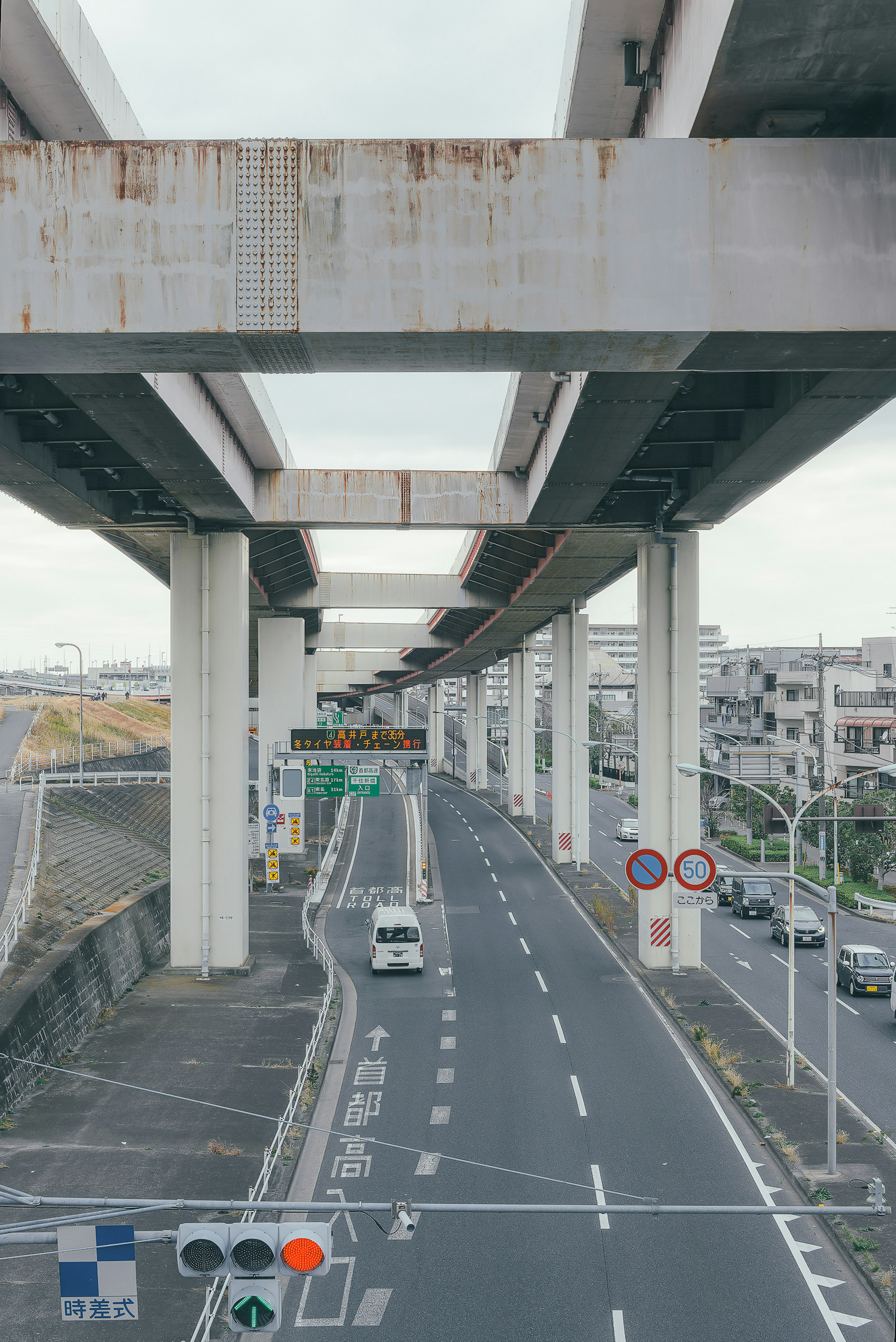 Blick auf eine Straße unter einer erhöhten Autobahn mit sichtbaren Stützpfeilern