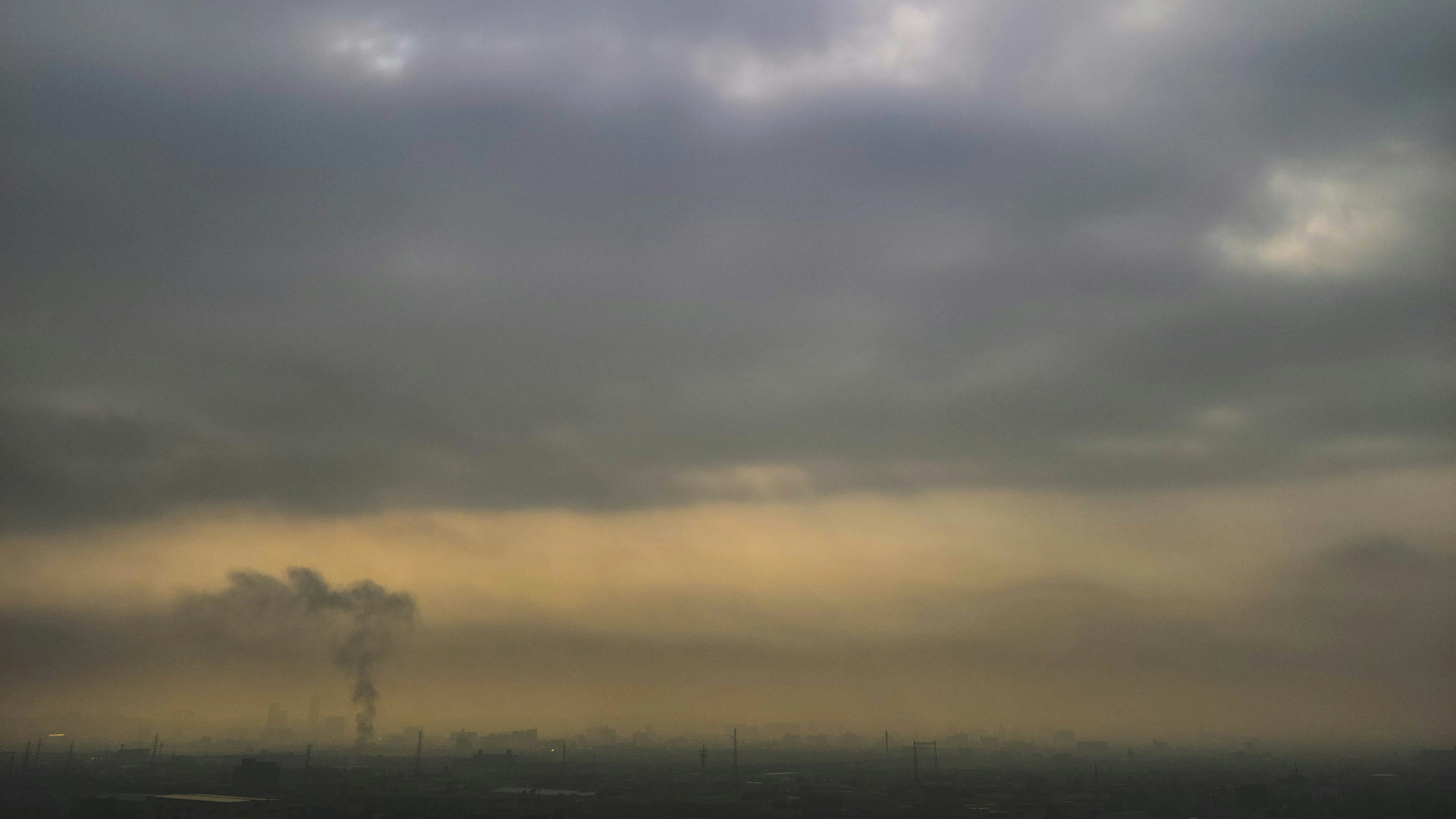 Pemandangan kota dengan langit mendung dan asap pabrik