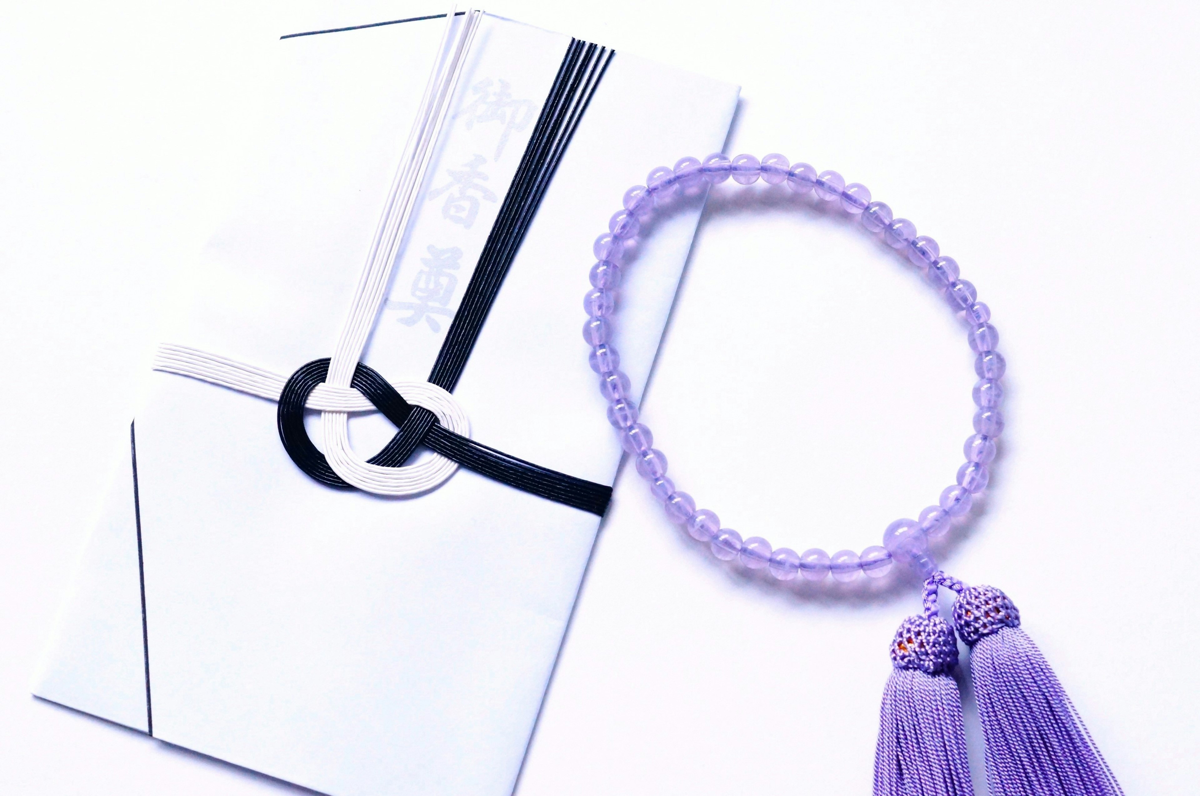 A beautiful styling featuring a purple tassel bracelet and a white envelope