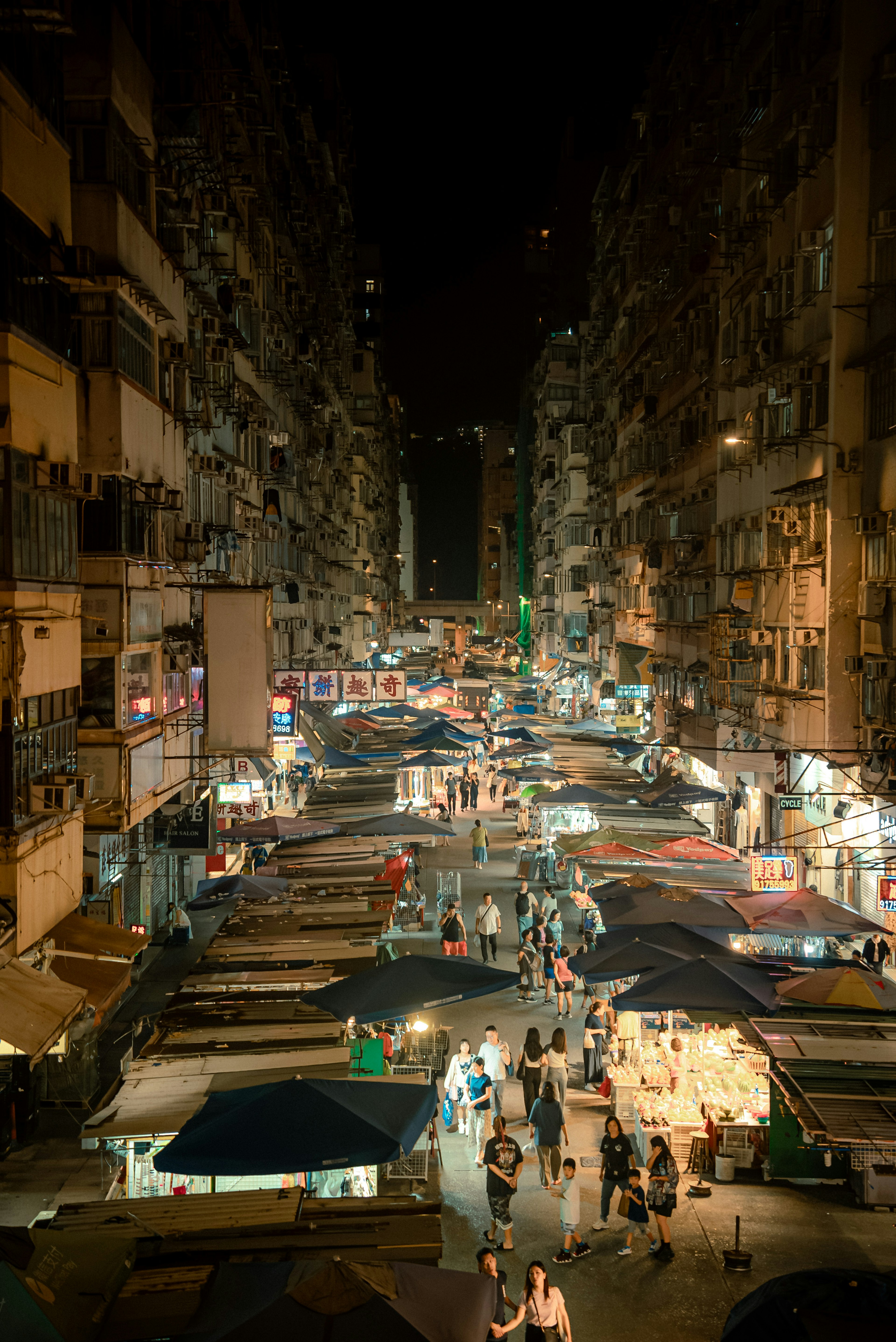 Bustling street market at night with food stalls and crowds