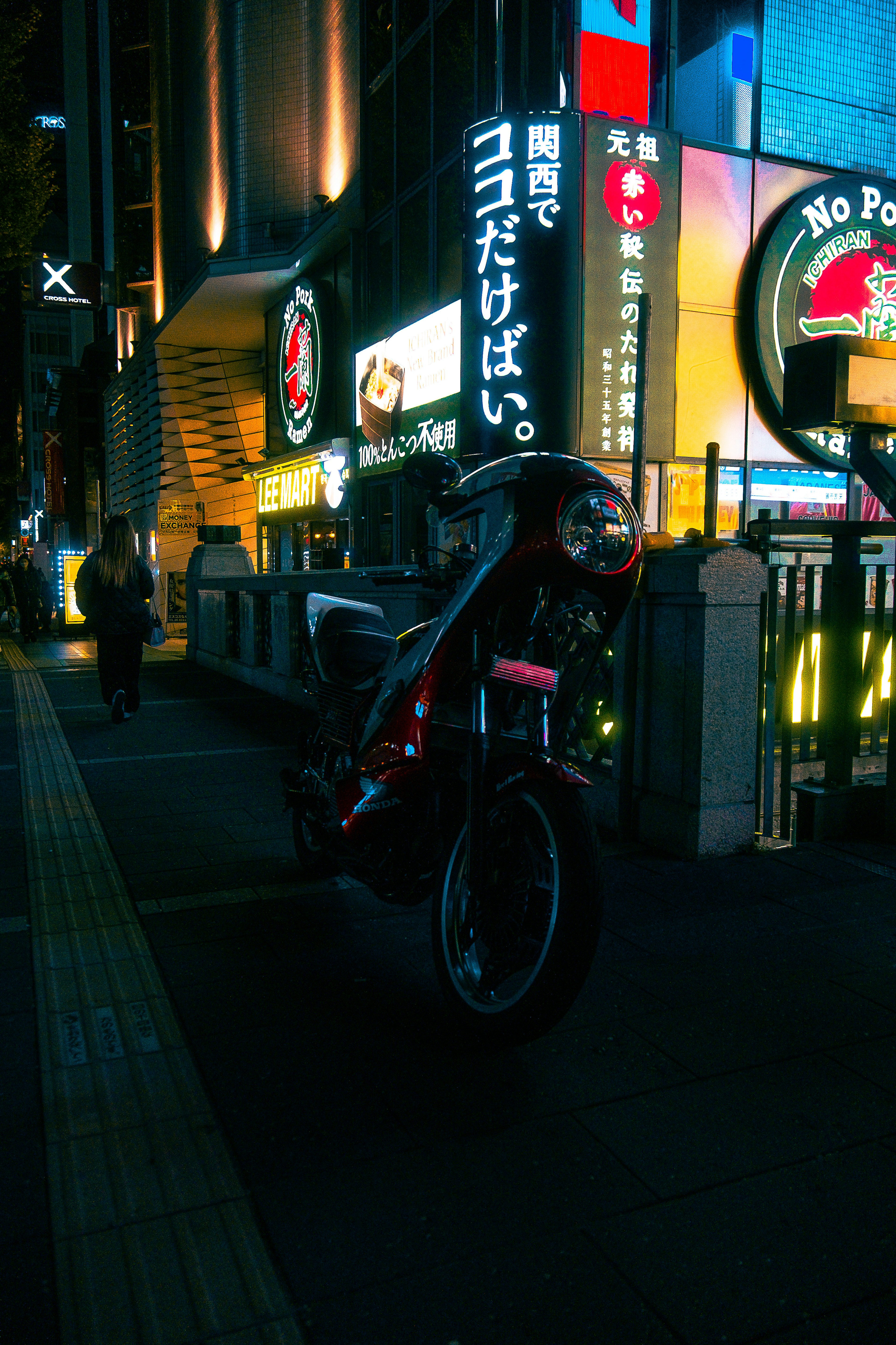 夜の街に停まる赤いバイクとネオン看板