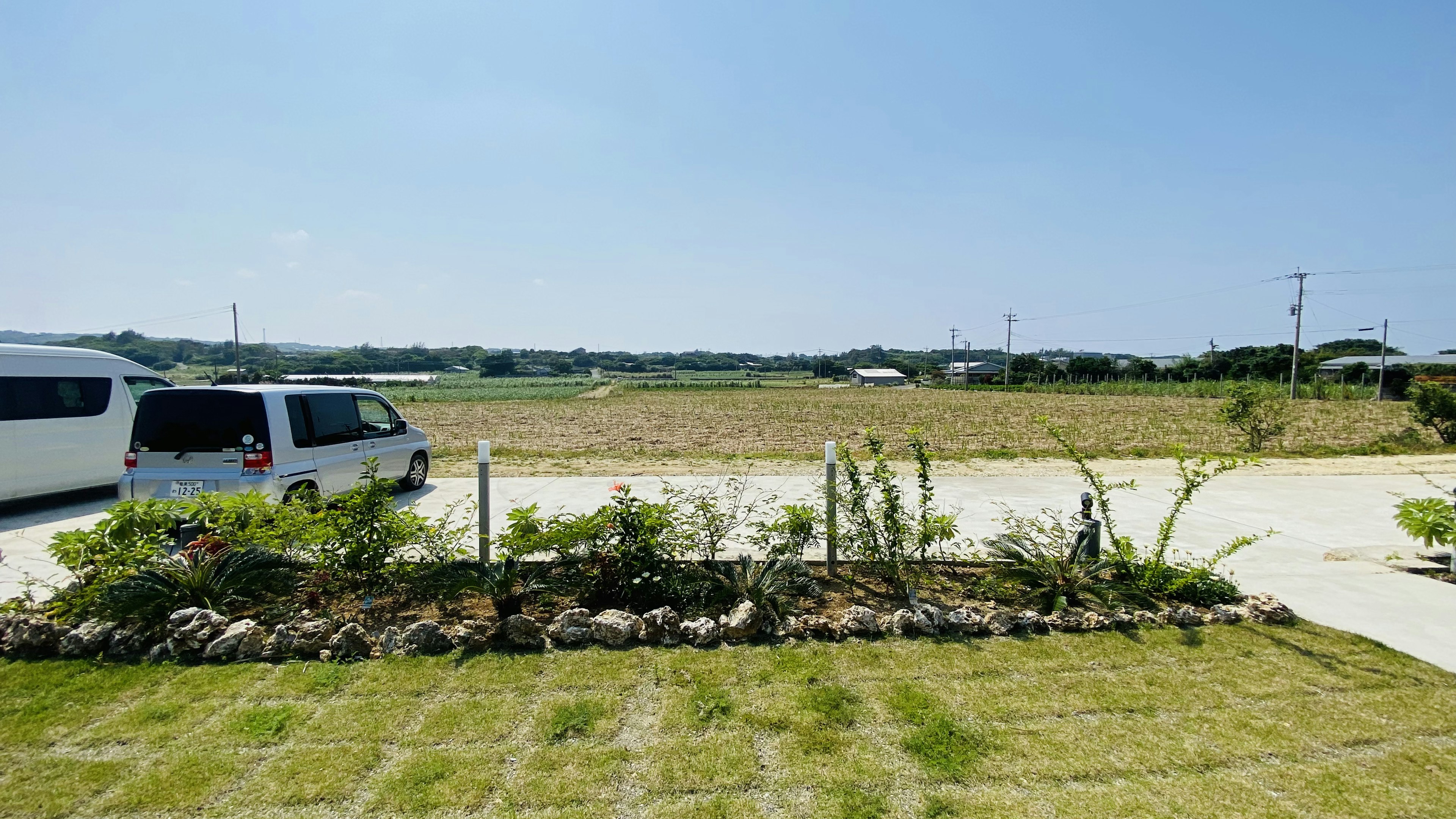 青空の下の庭と車の景観 農地が広がる