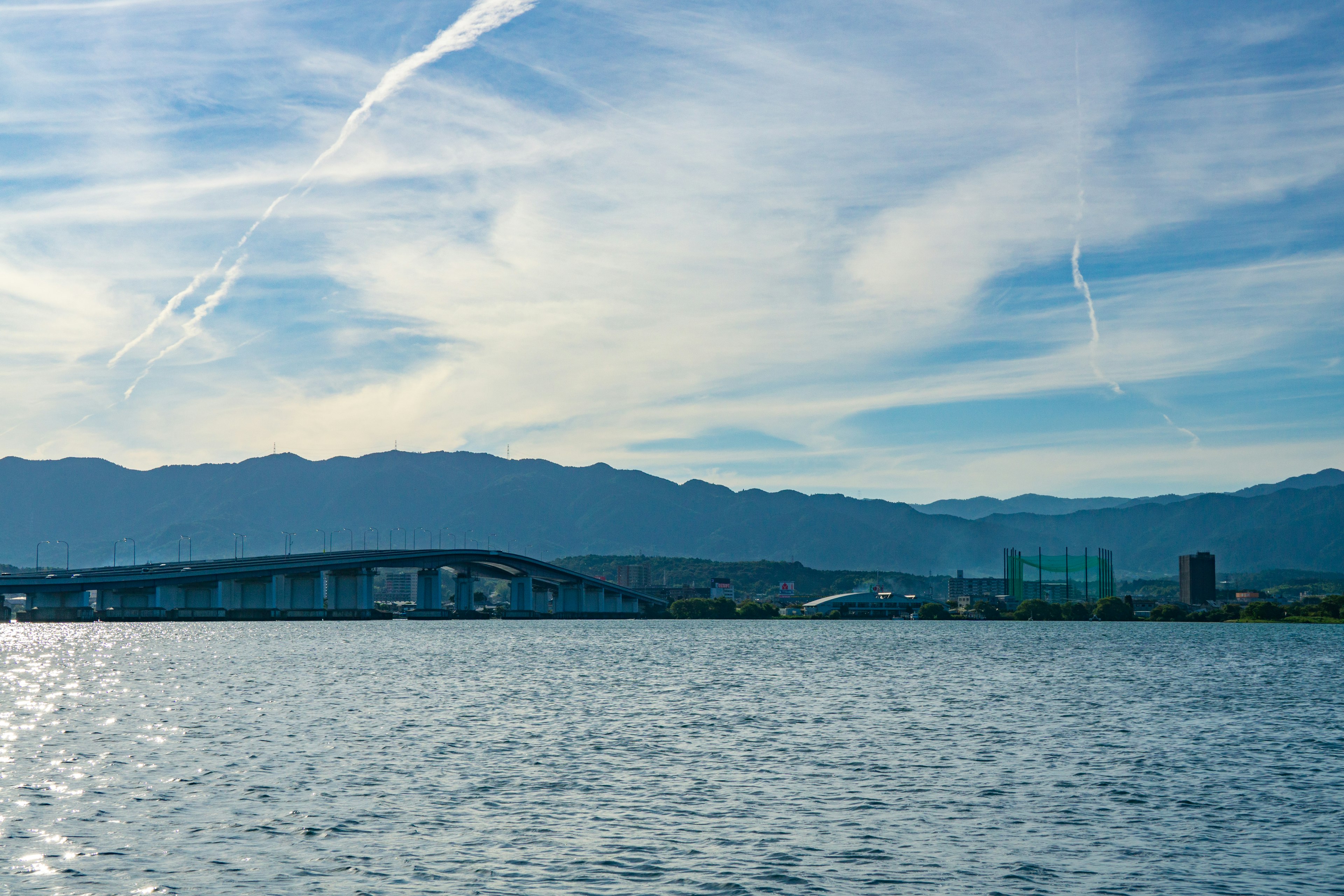 Vista escénica de un puente y montañas contra un cielo azul con nubes