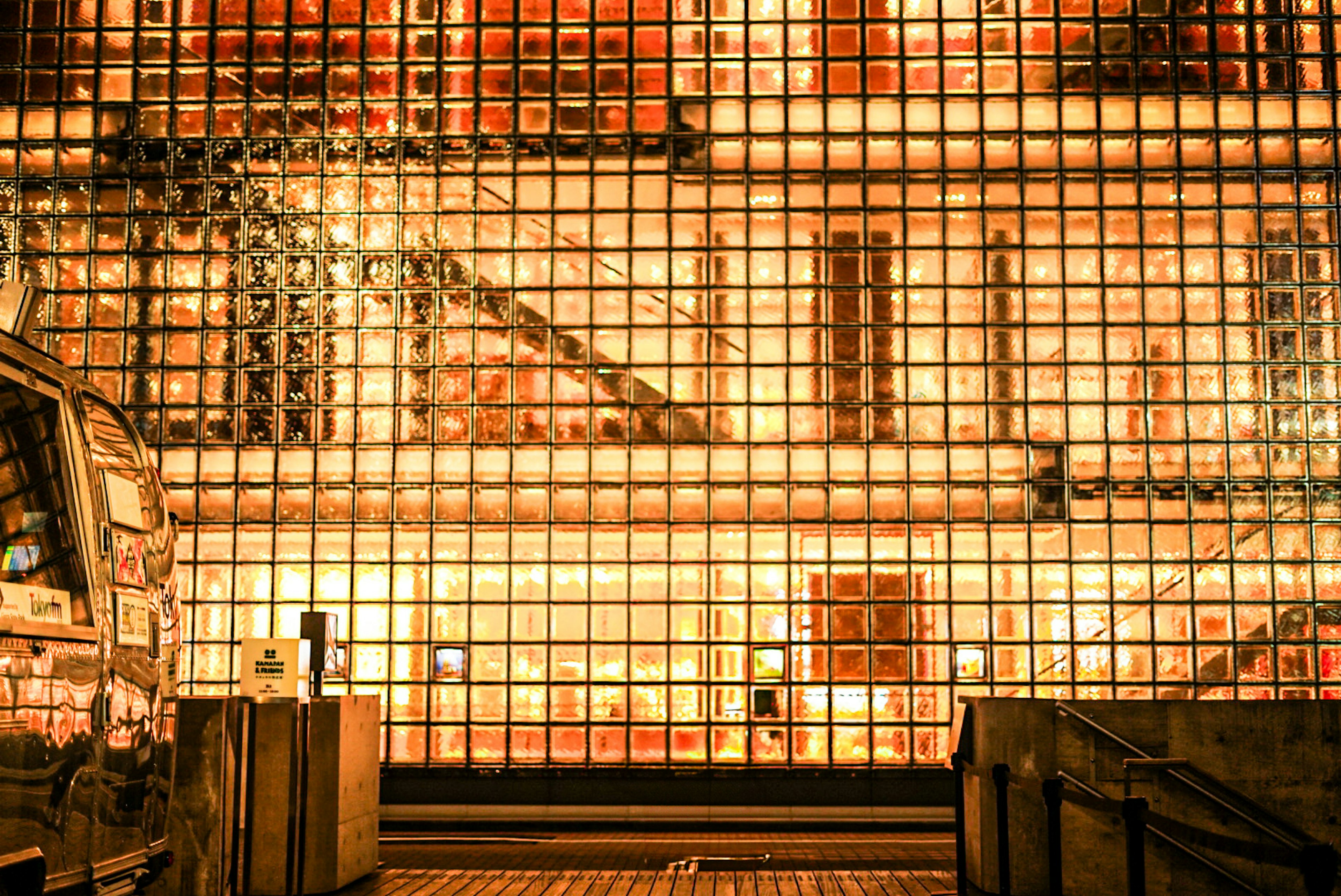 Intérieur d'un bâtiment avec un mur en verre et des escaliers illuminés