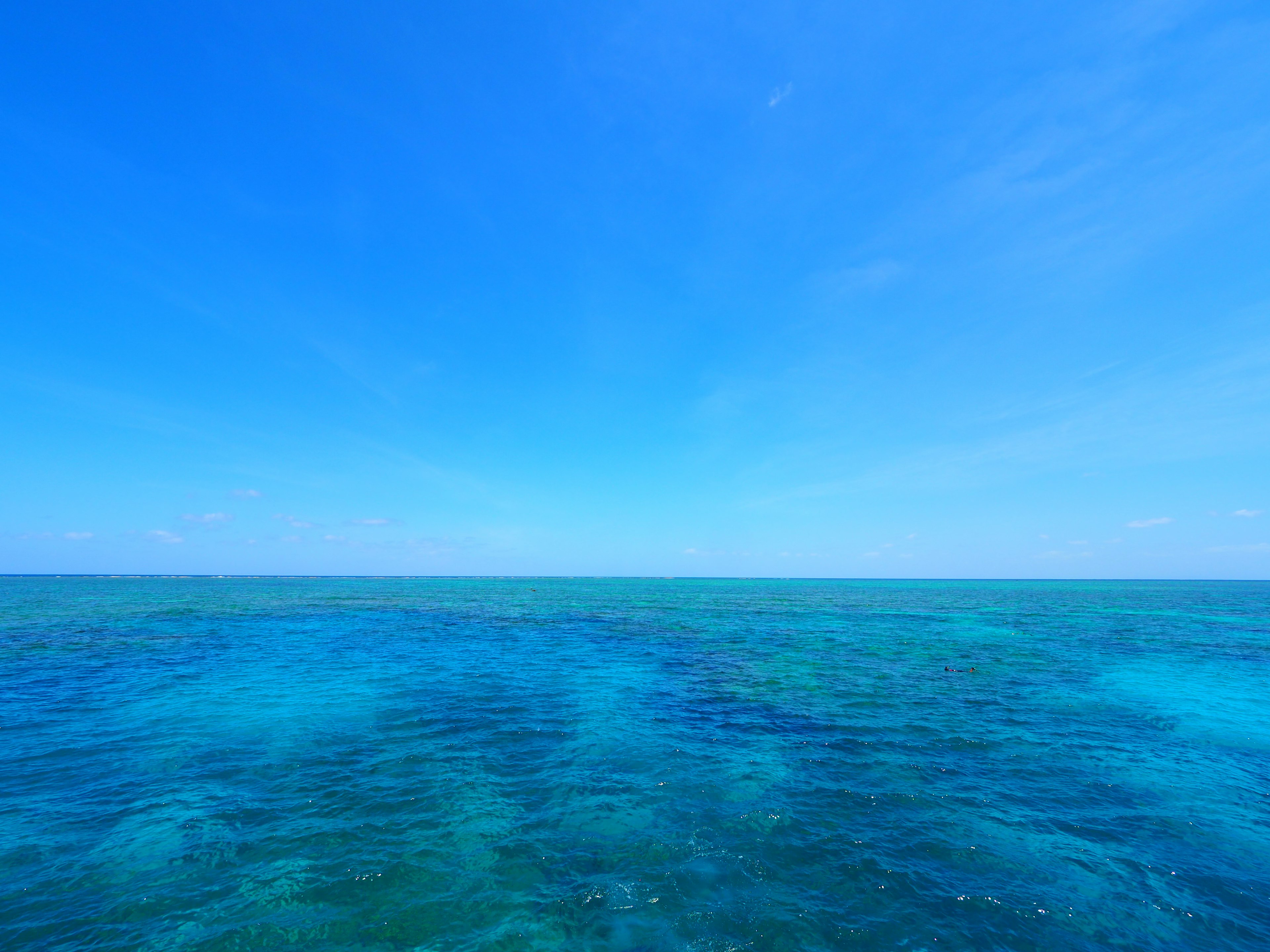 Vasto oceano blu che incontra un cielo azzurro