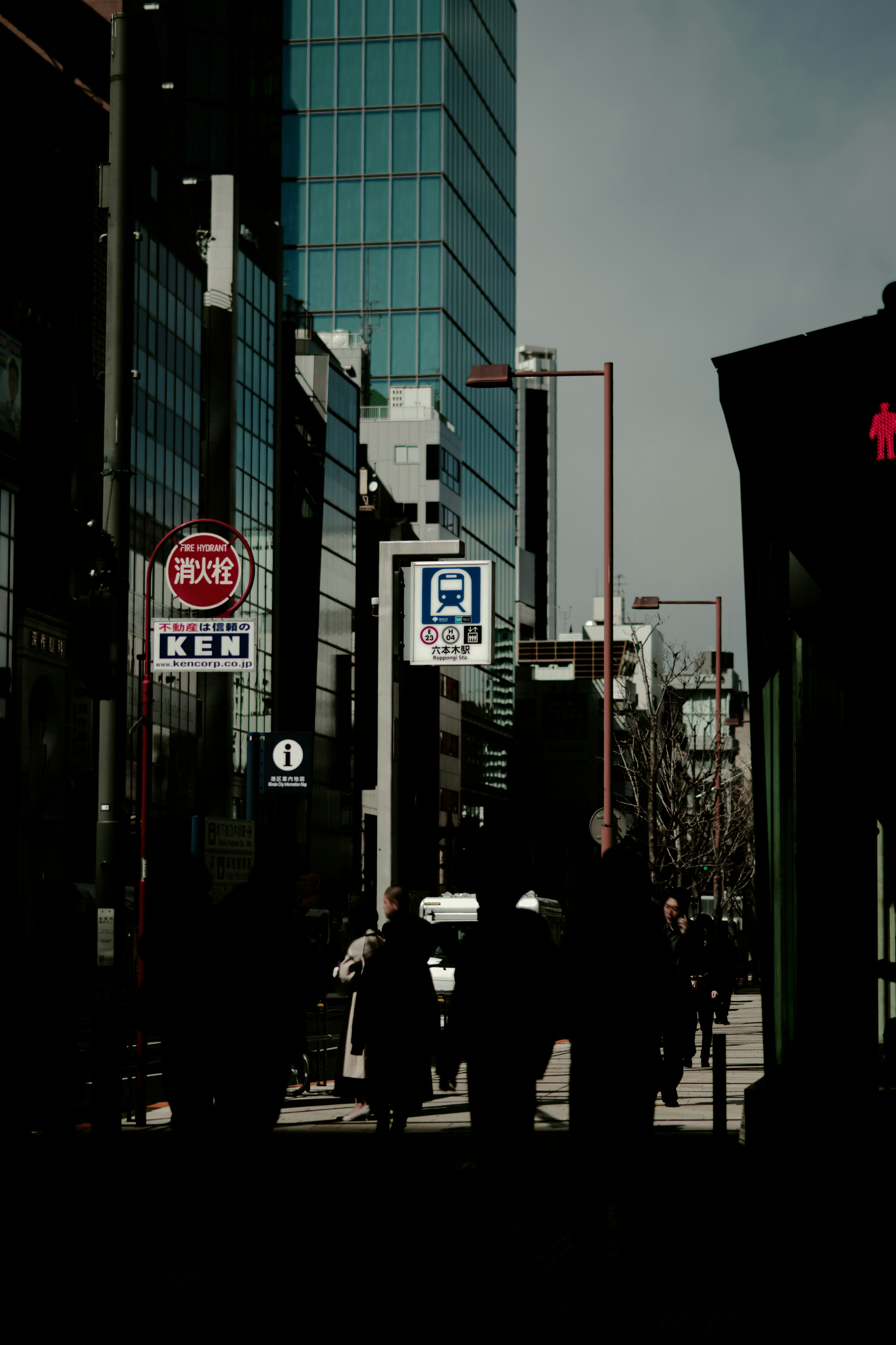 Silhouettes of people walking with high-rise buildings in the background