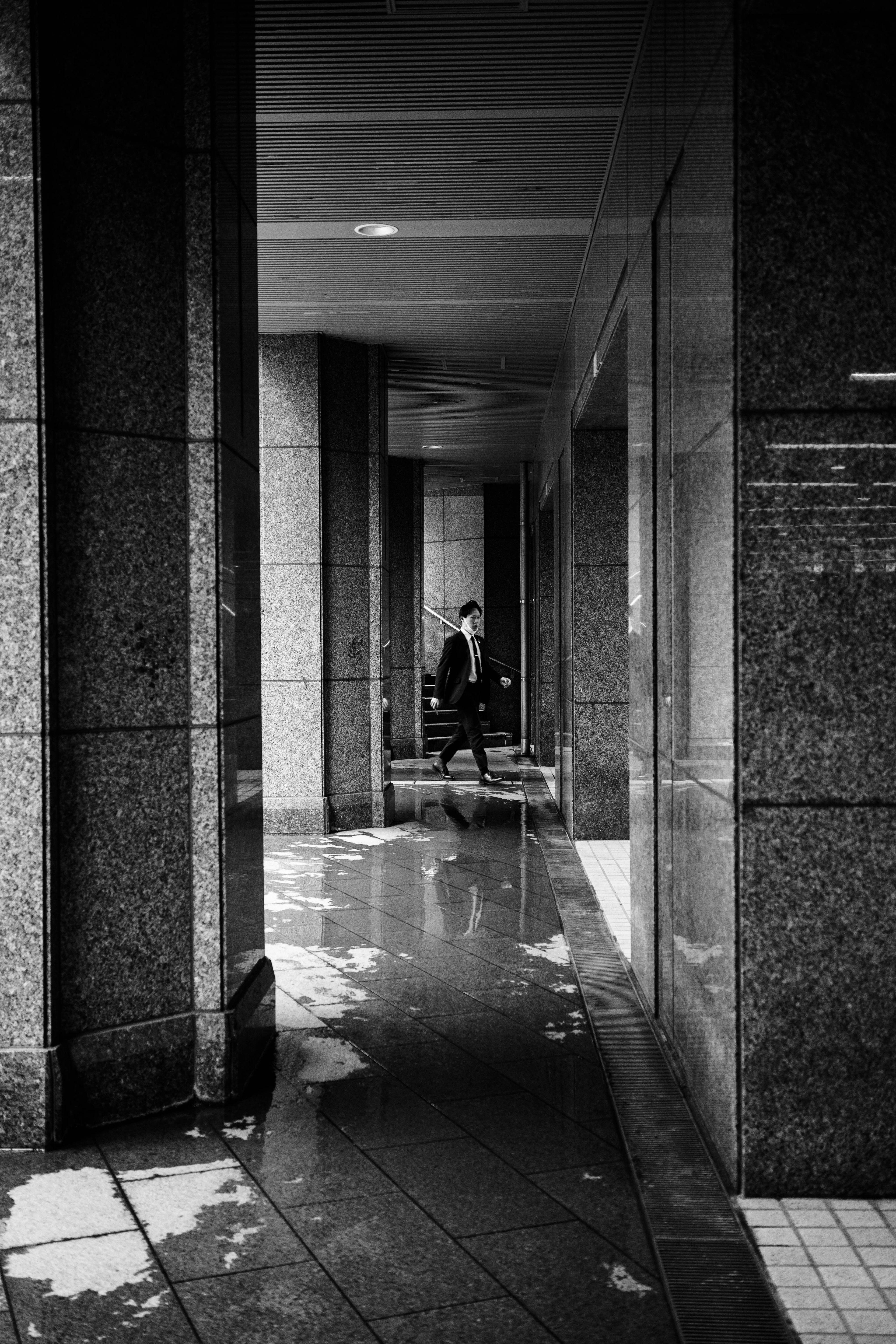 Silhouette of a person standing in a city corridor with striking black and white contrast