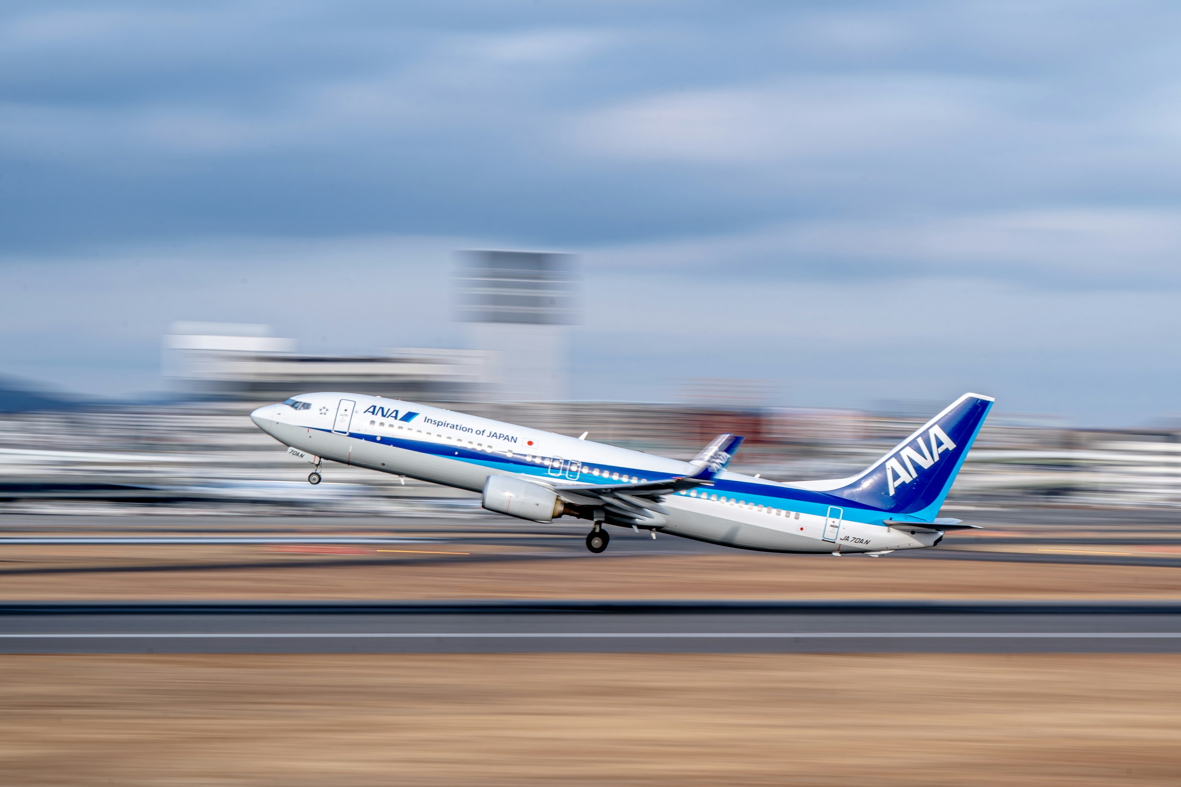 ANAの旅客機が滑走路を離陸する瞬間 青空と雲の背景