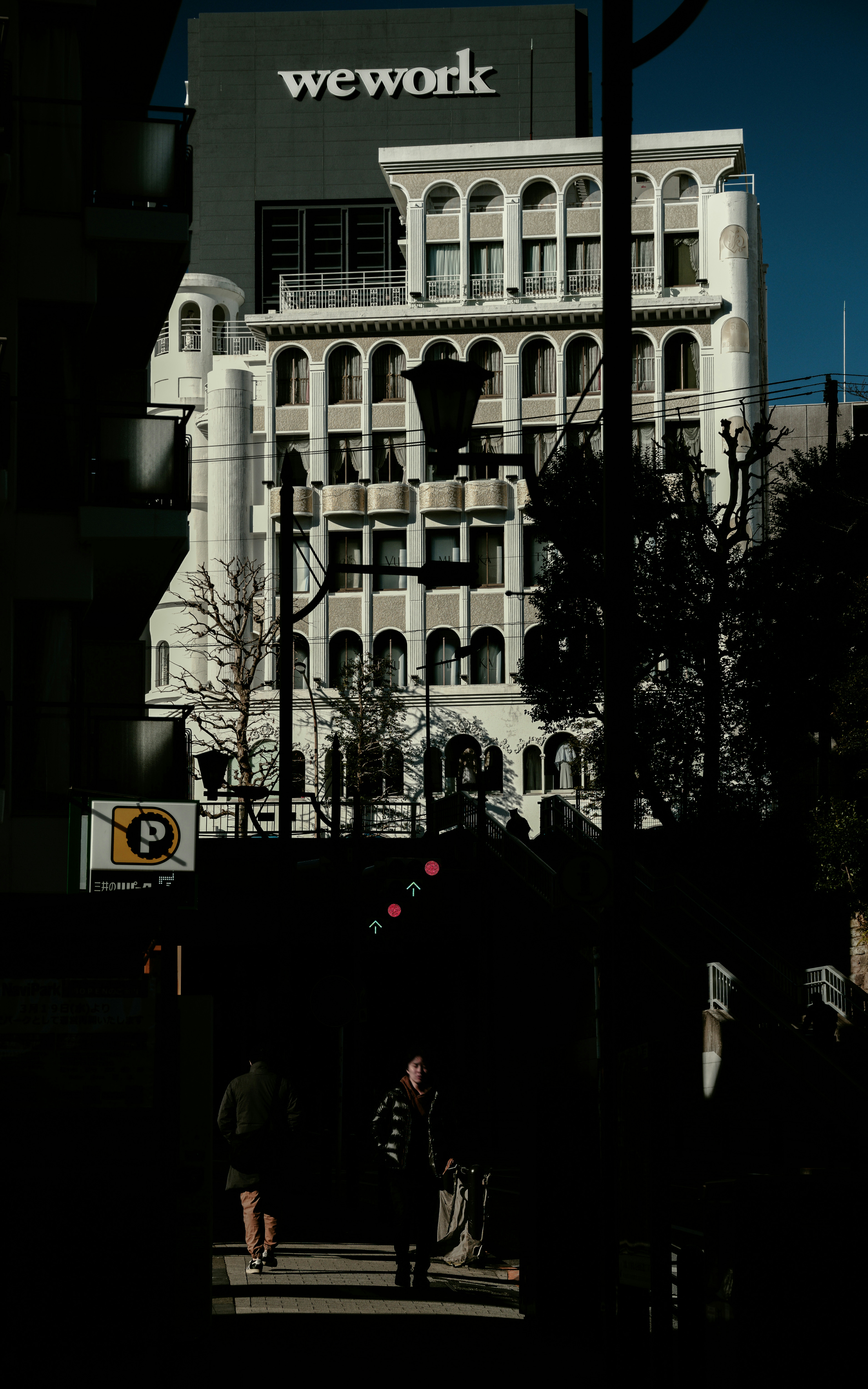 Un bâtiment blanc sous un ciel bleu avec un panneau WeWork