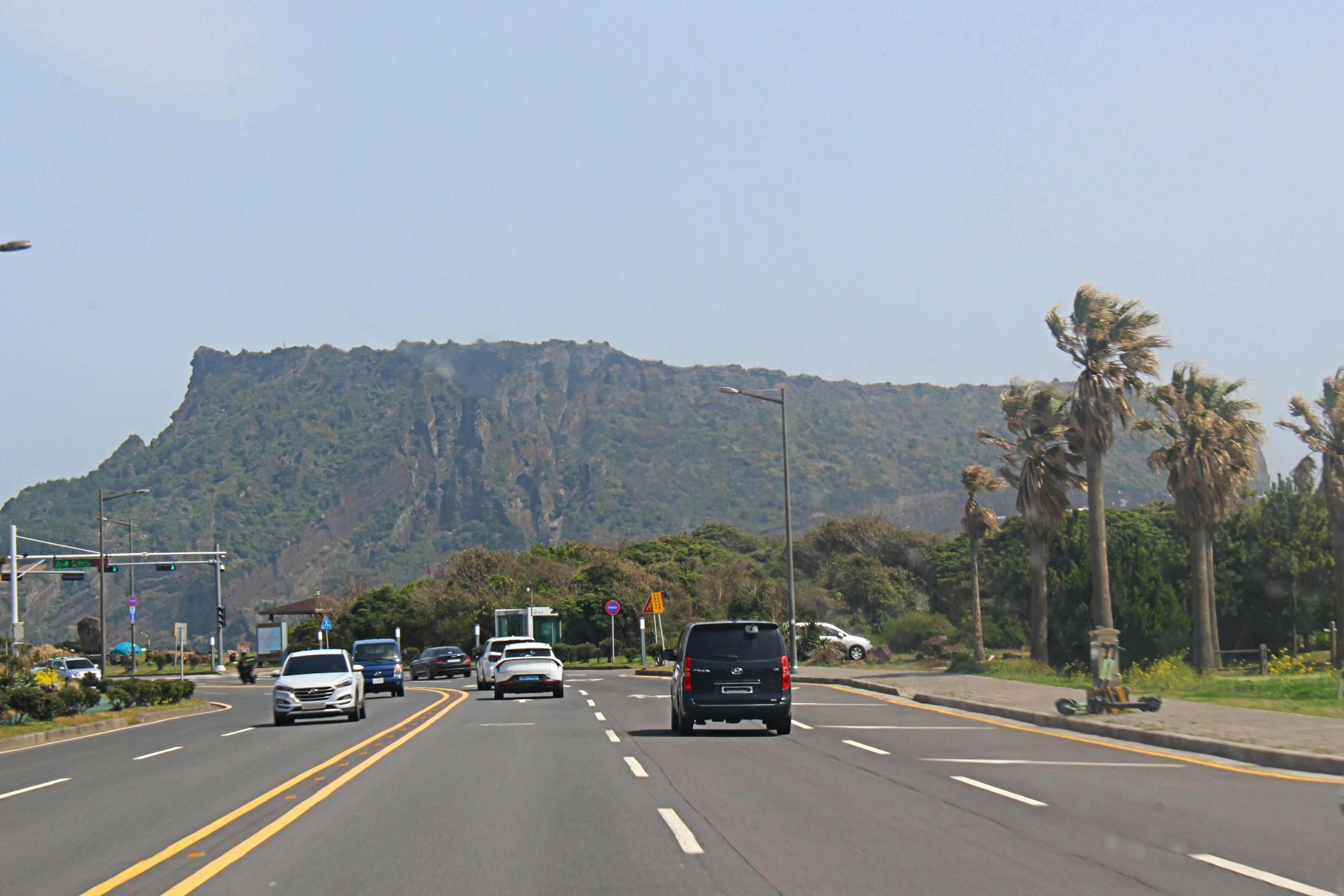 Vista escénica de una carretera con coches y una montaña al fondo