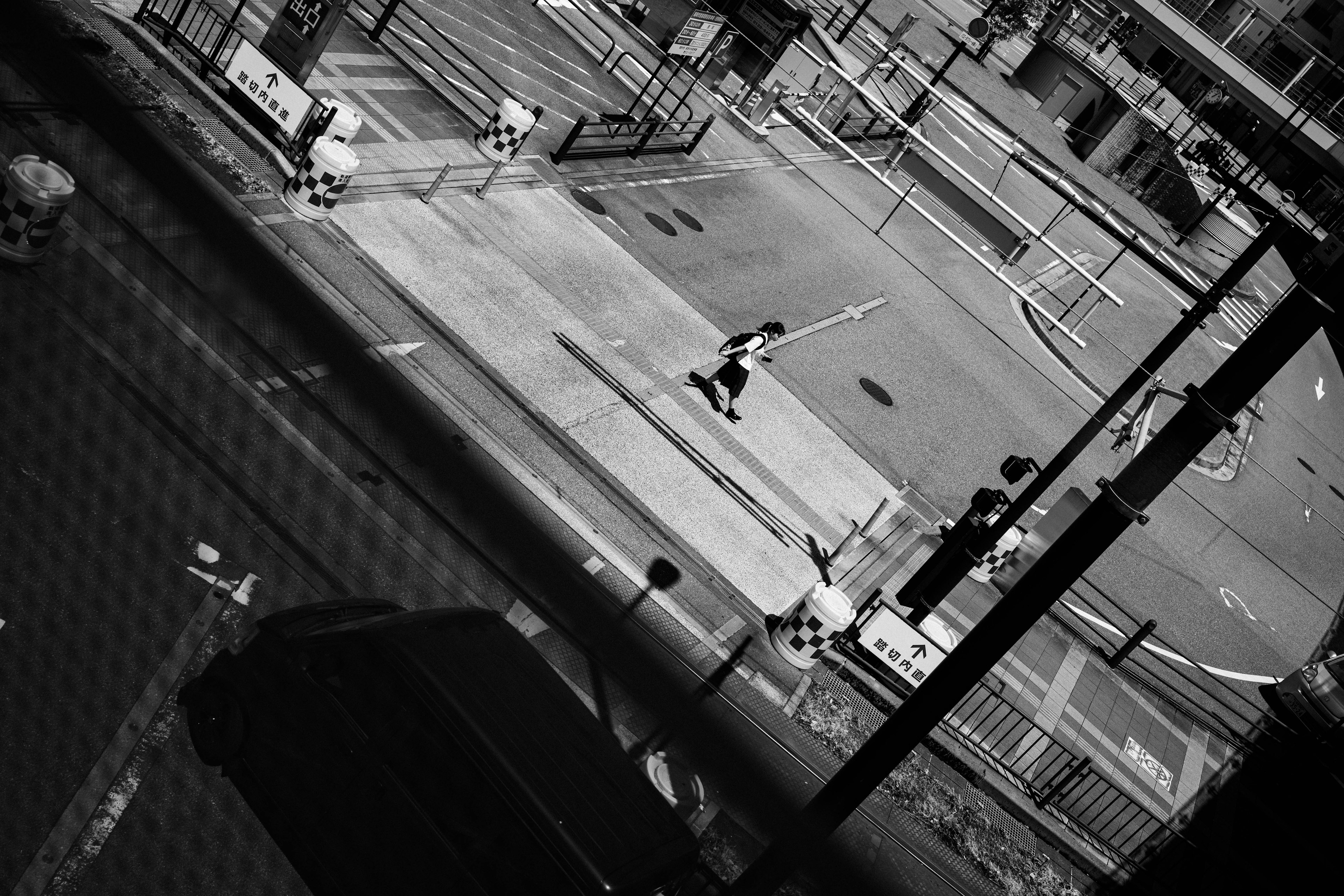 Black and white street scene with a person crossing the road