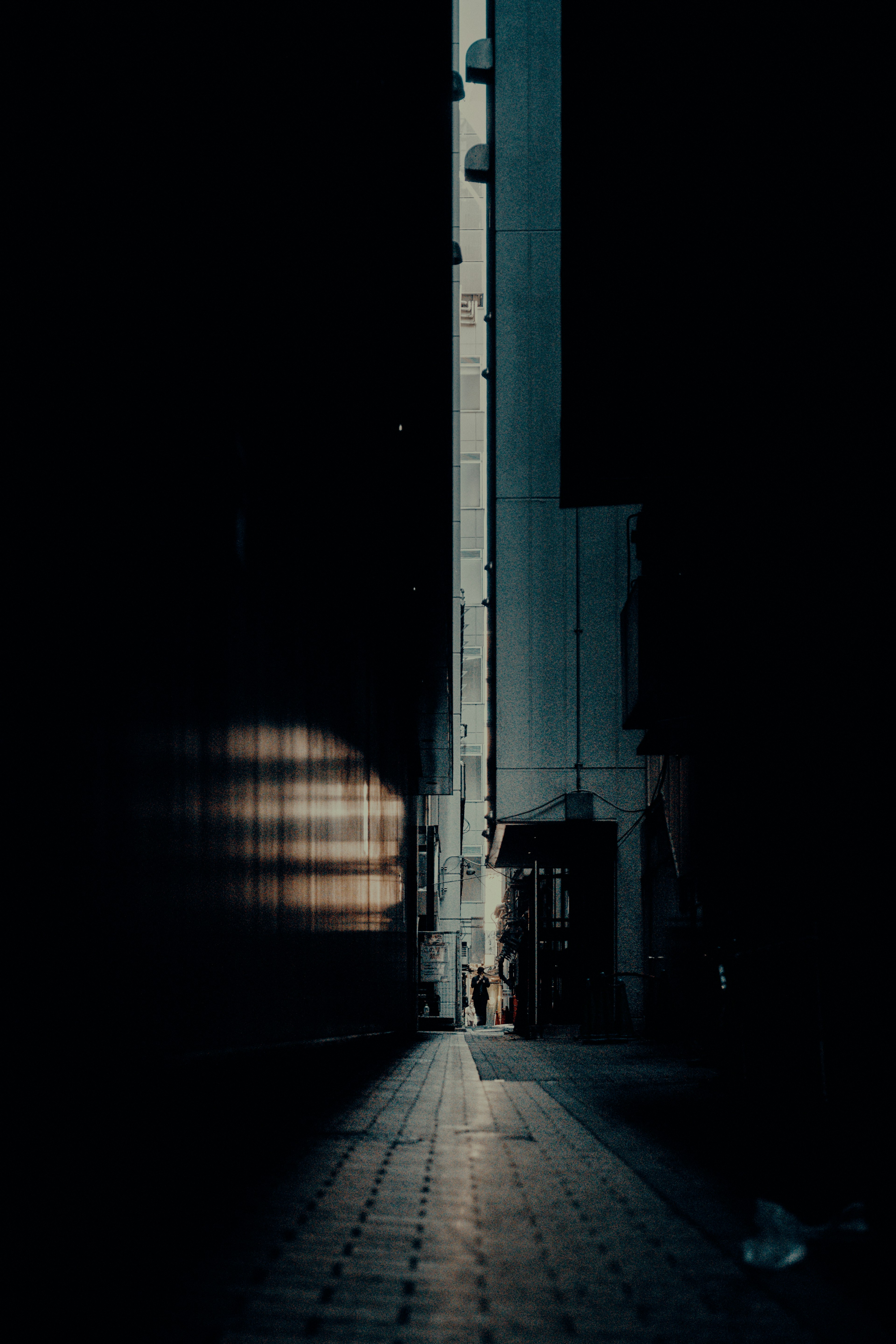 Narrow alleyway illuminated by a beam of light