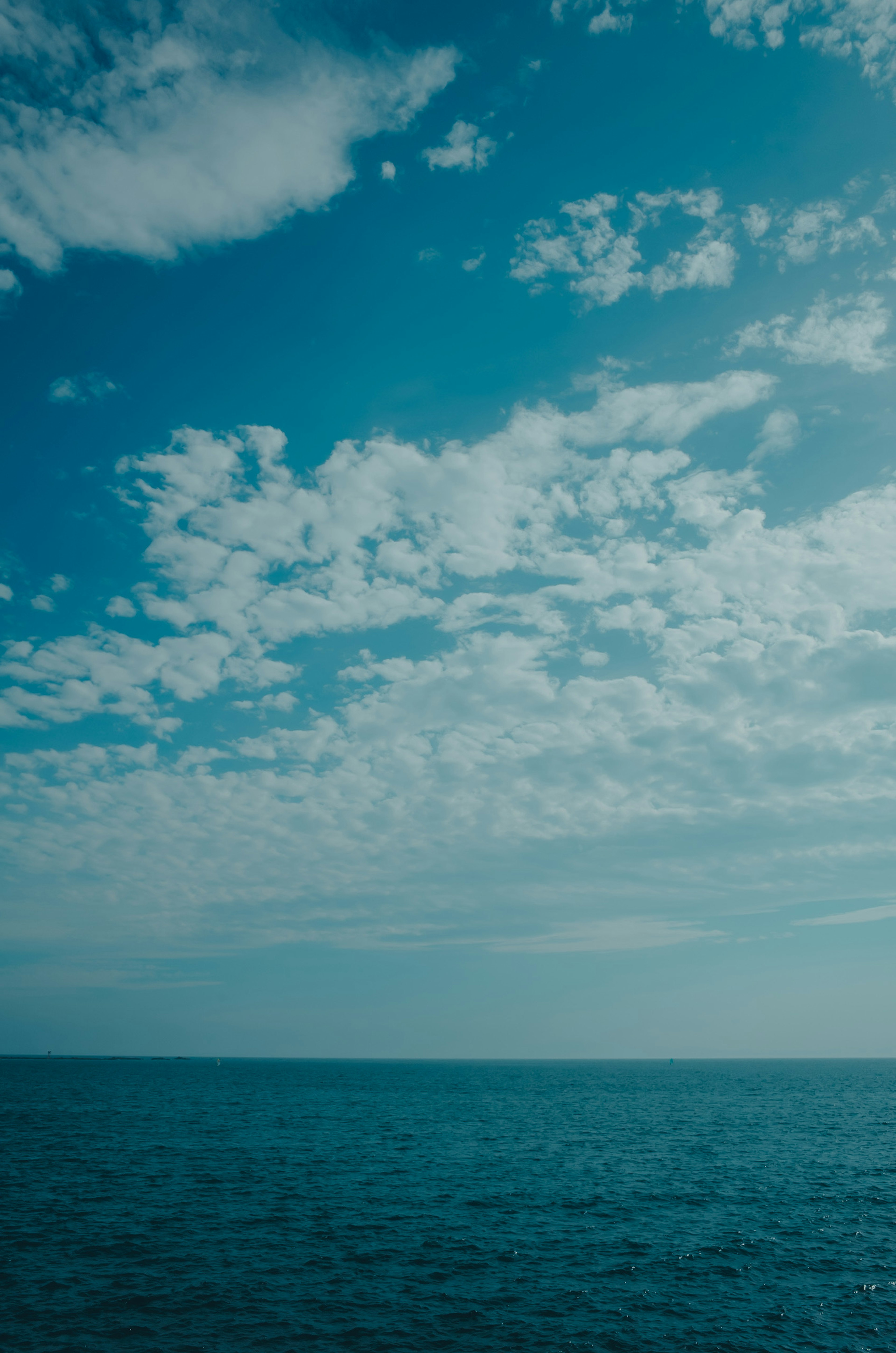 Scenic view of blue ocean and cloudy sky
