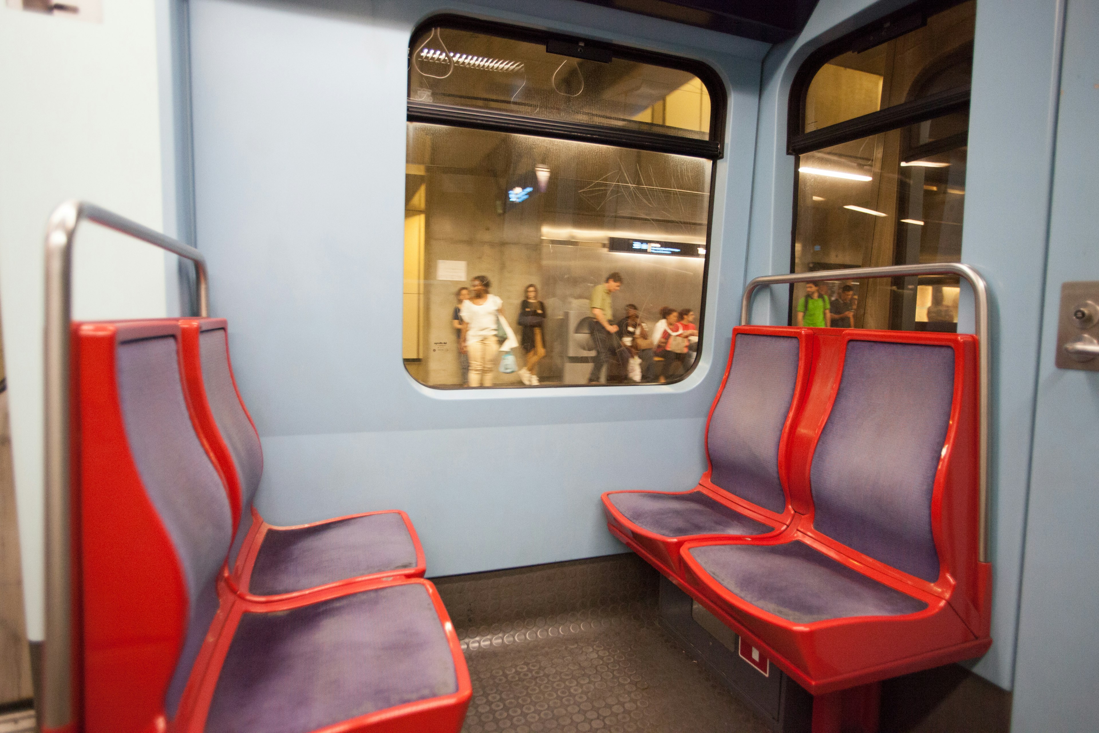 Intérieur d'une voiture de train avec des murs bleus et des bancs rouges