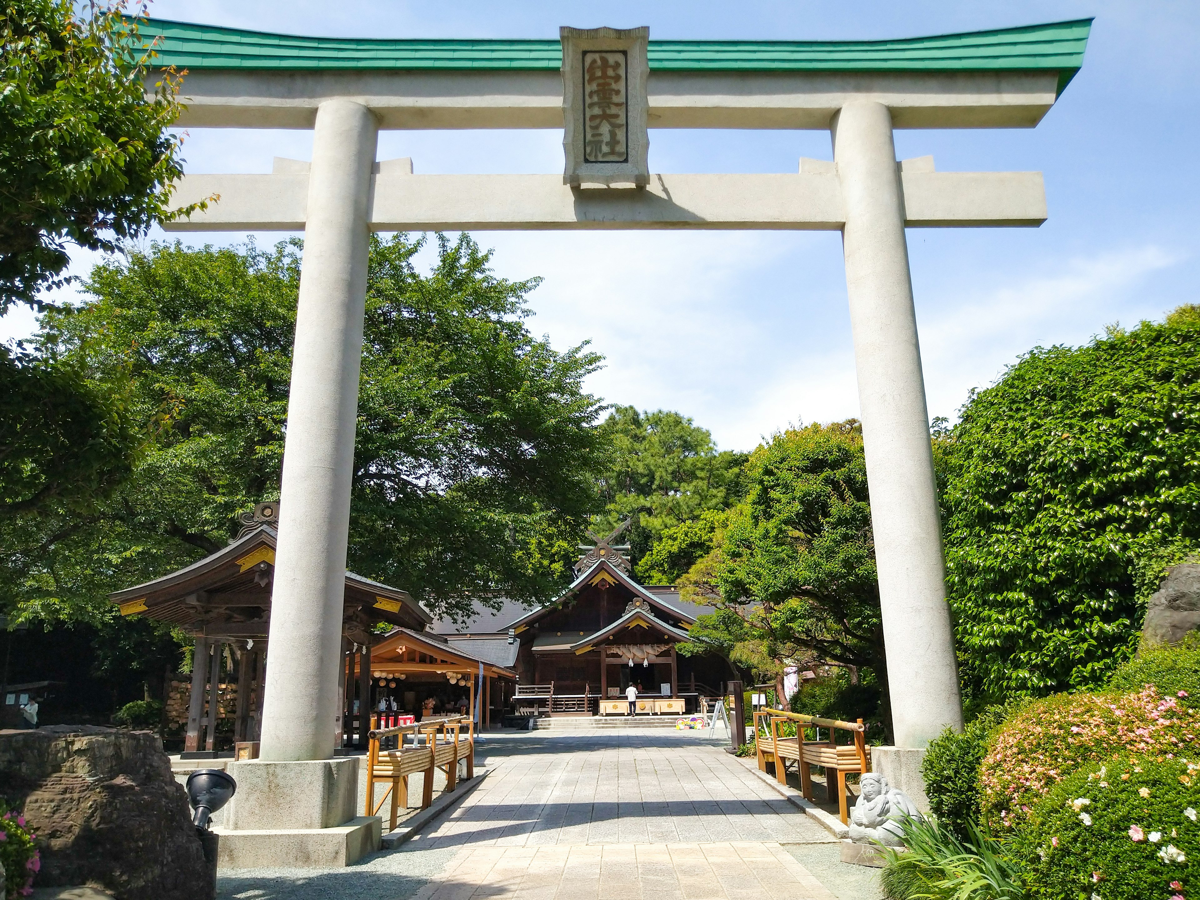 Große Torii-Tor und Schrein umgeben von üppigem Grün