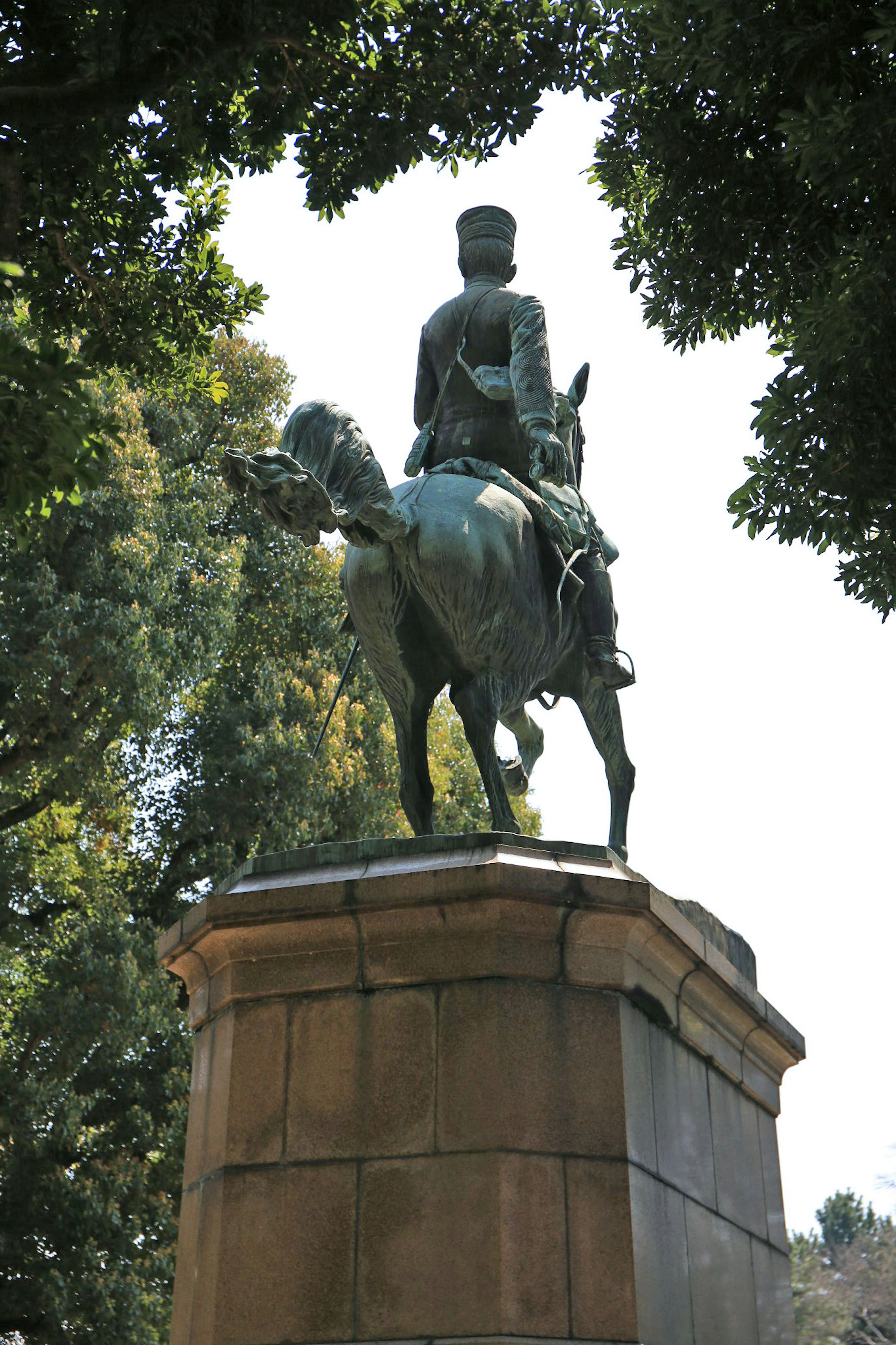 Bronze statue of a knight on horseback in a park setting