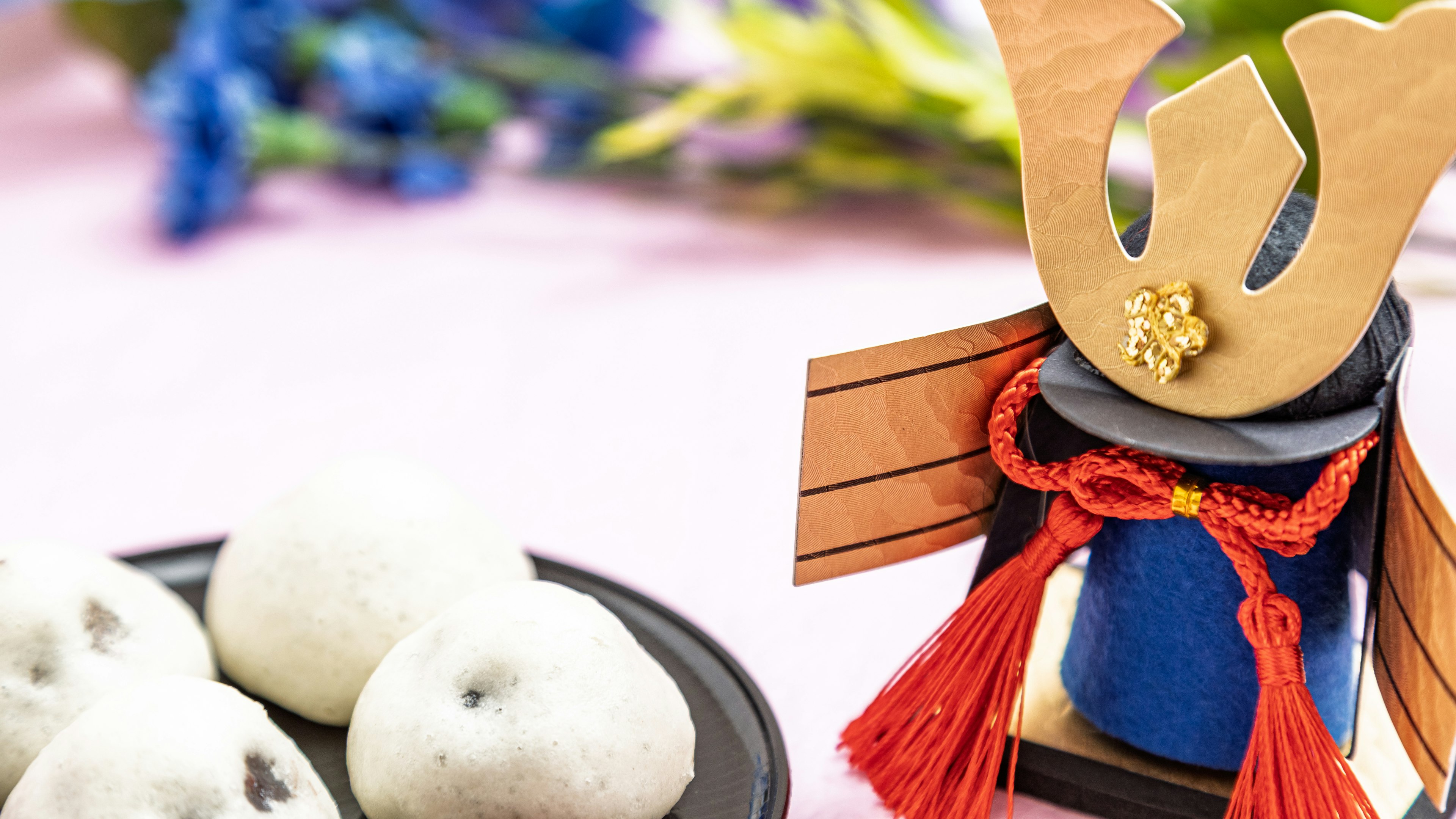 Casco tradicional de samurái con bolitas blancas en una mesa decorativa