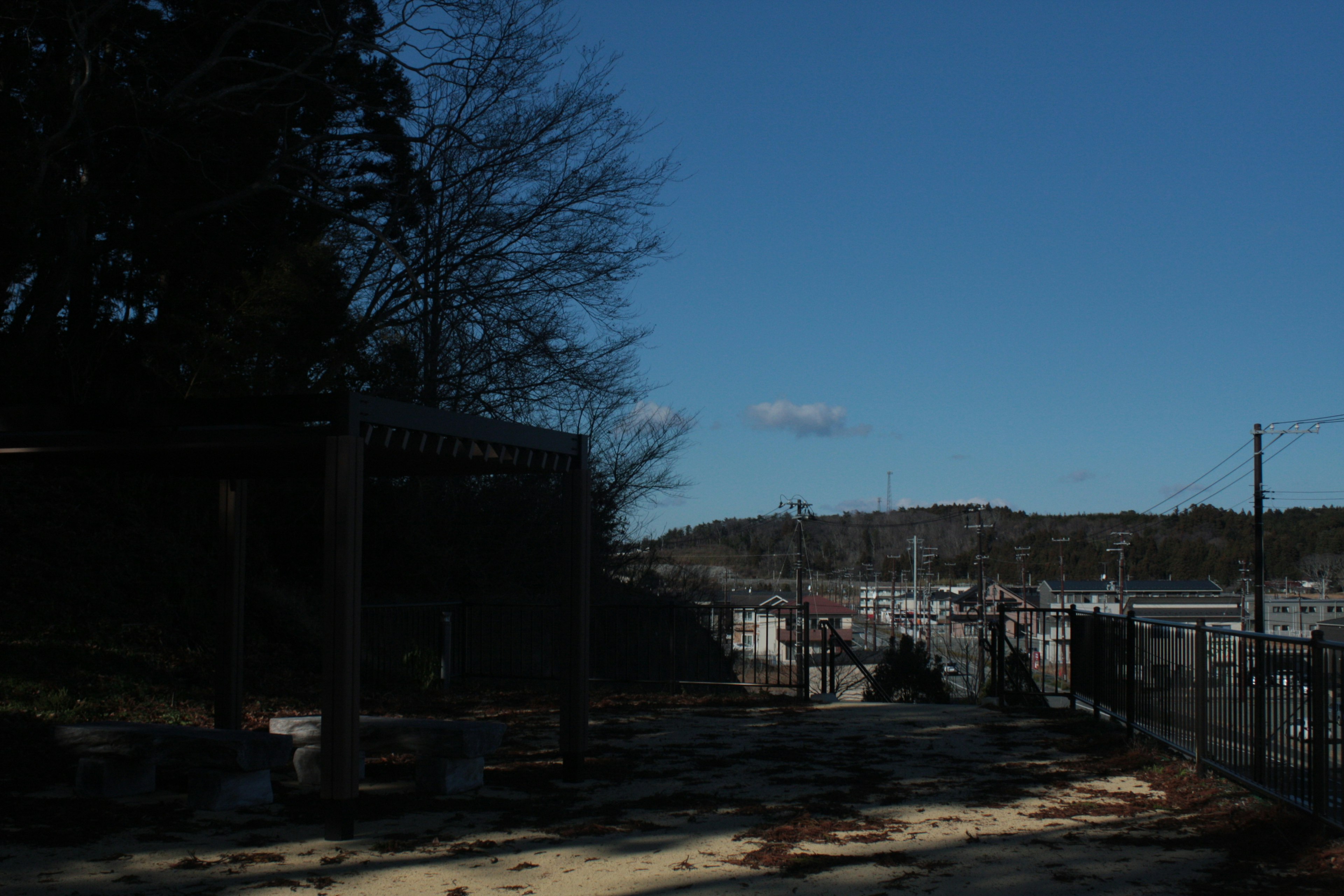 Landscape under blue sky with partial view of buildings