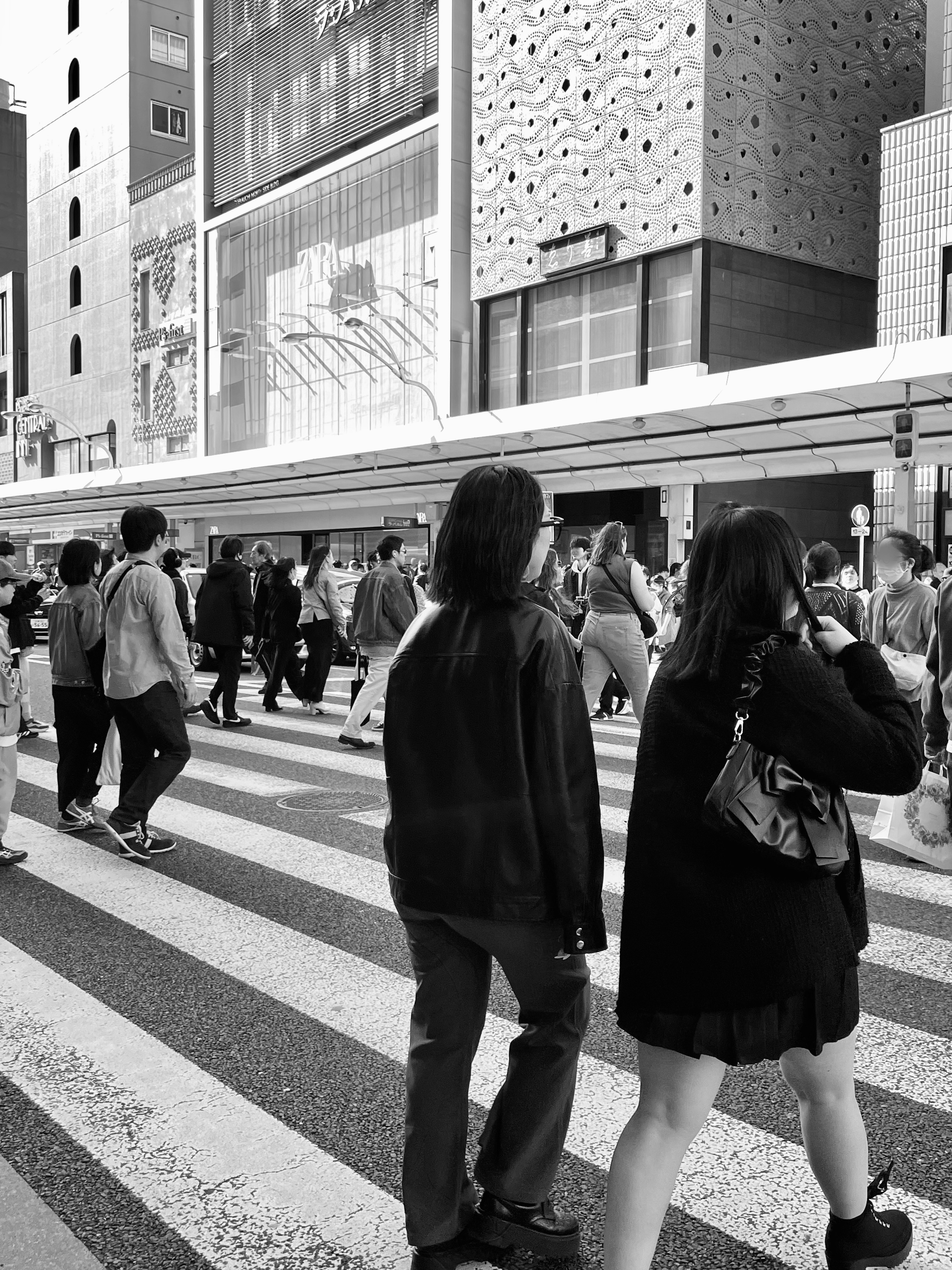 Crowd of people crossing a pedestrian street in black and white