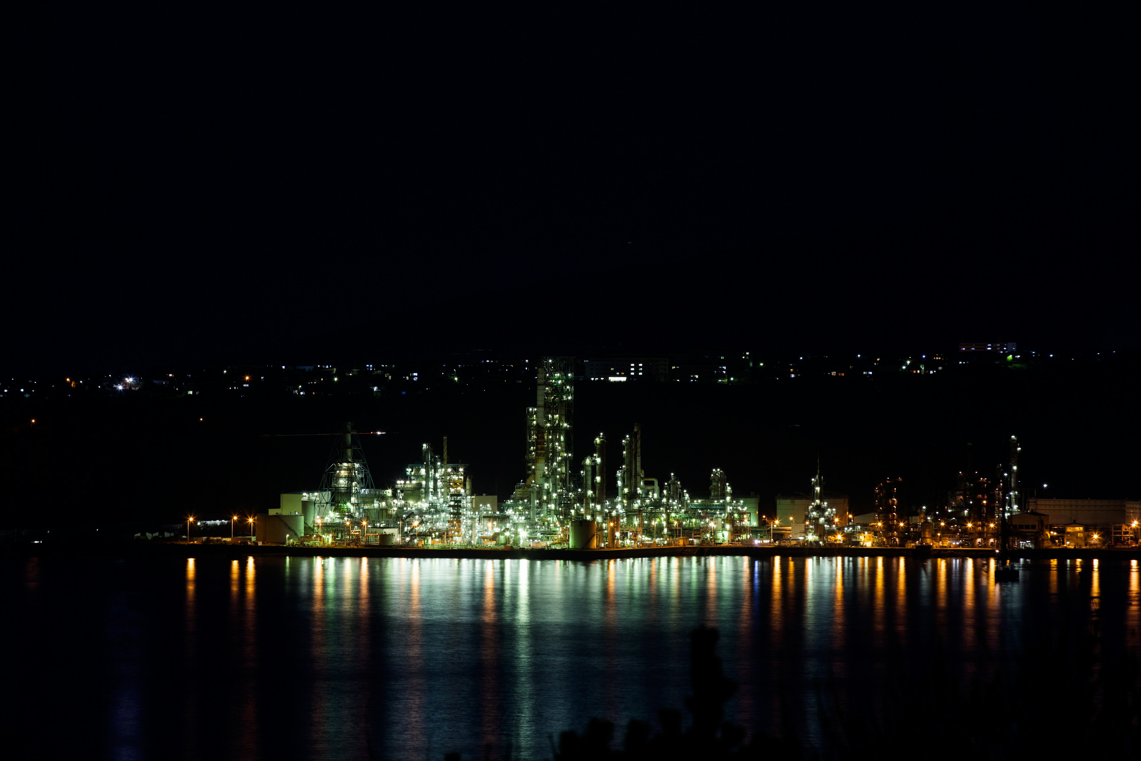 Night view of a factory with lights reflecting on the water