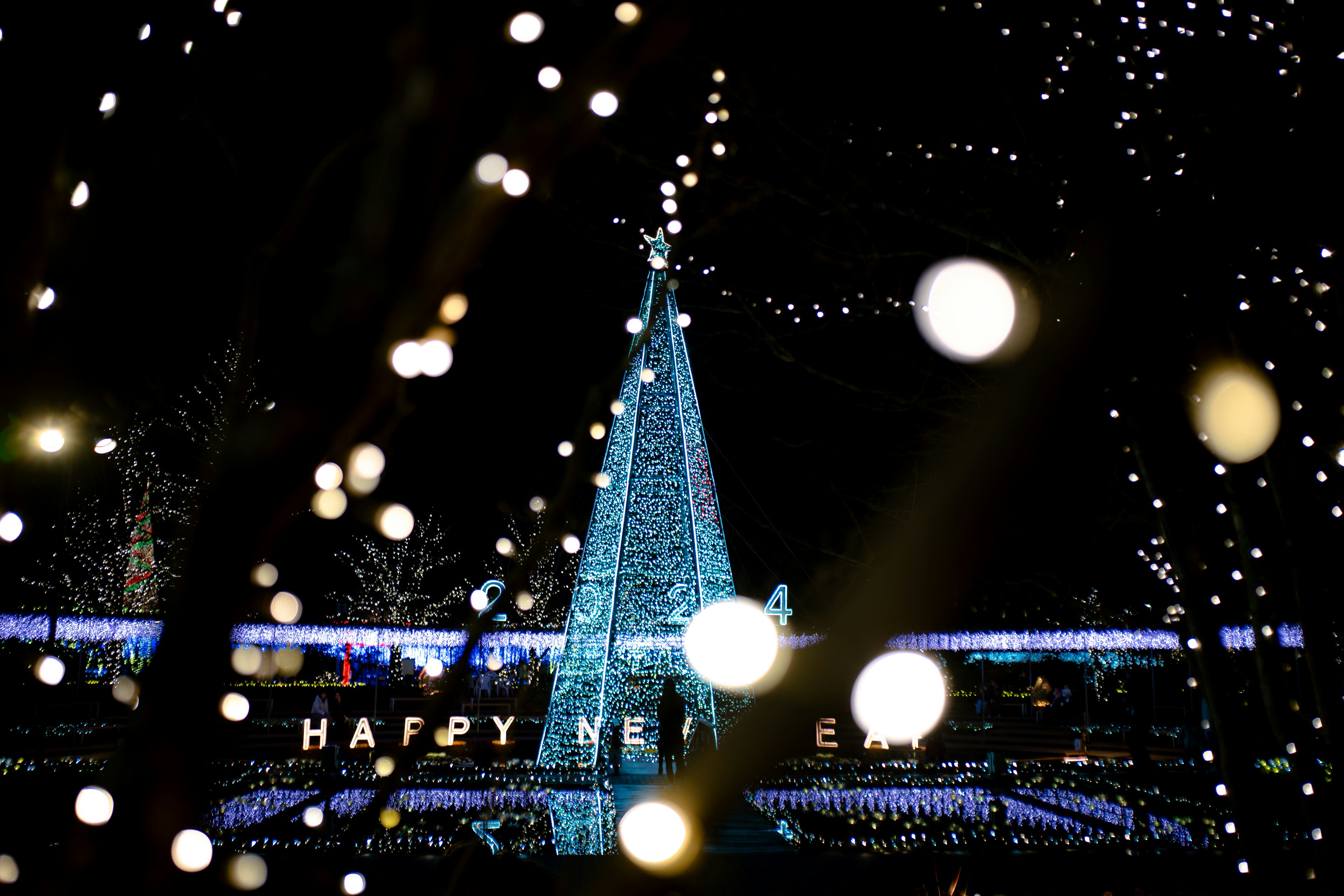 夜のクリスマスツリーと光の装飾が施された風景