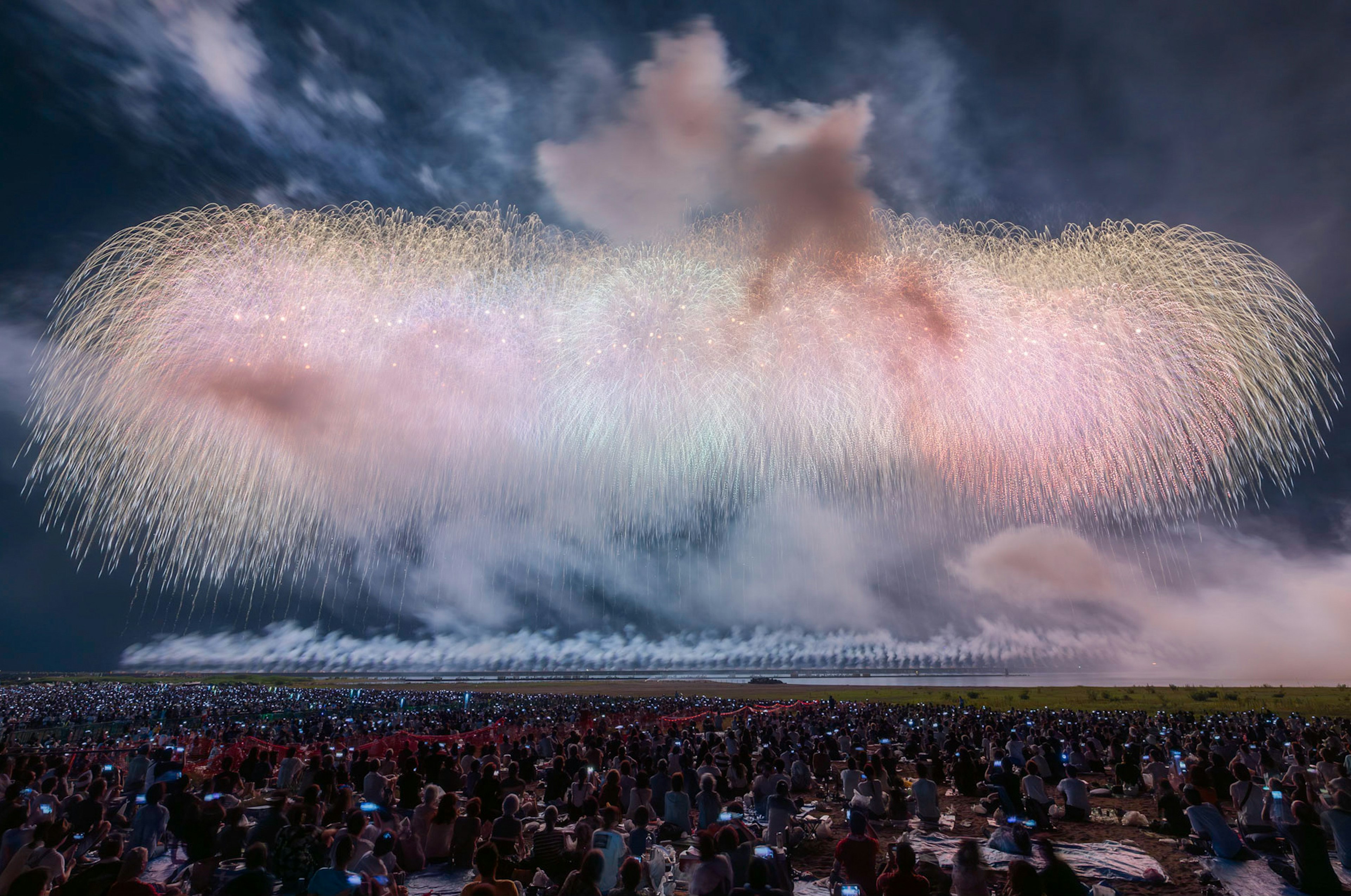 Spectacular fireworks display over a large crowd at a festival