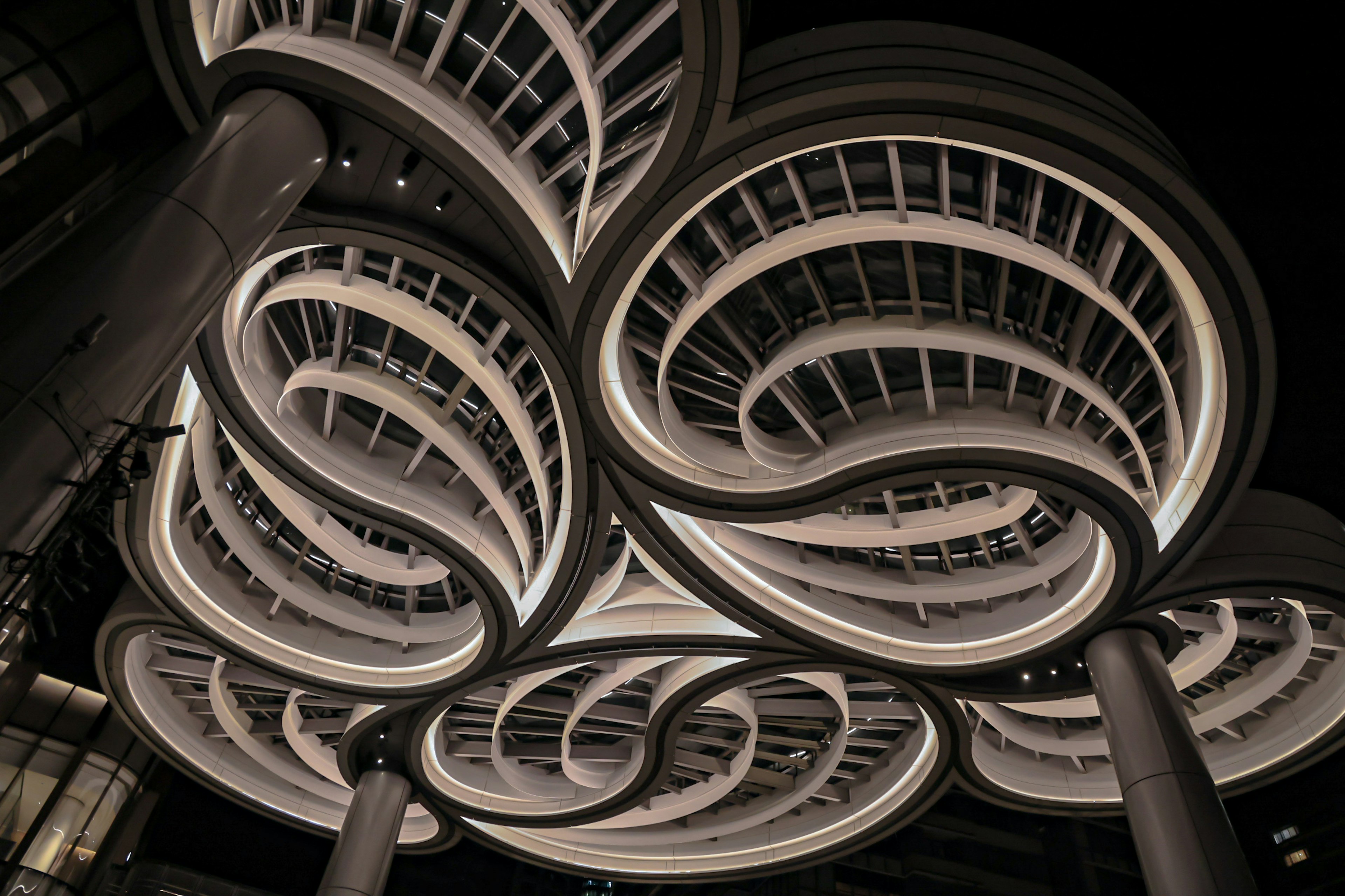 Unique spiral ceiling design in a building interior at night