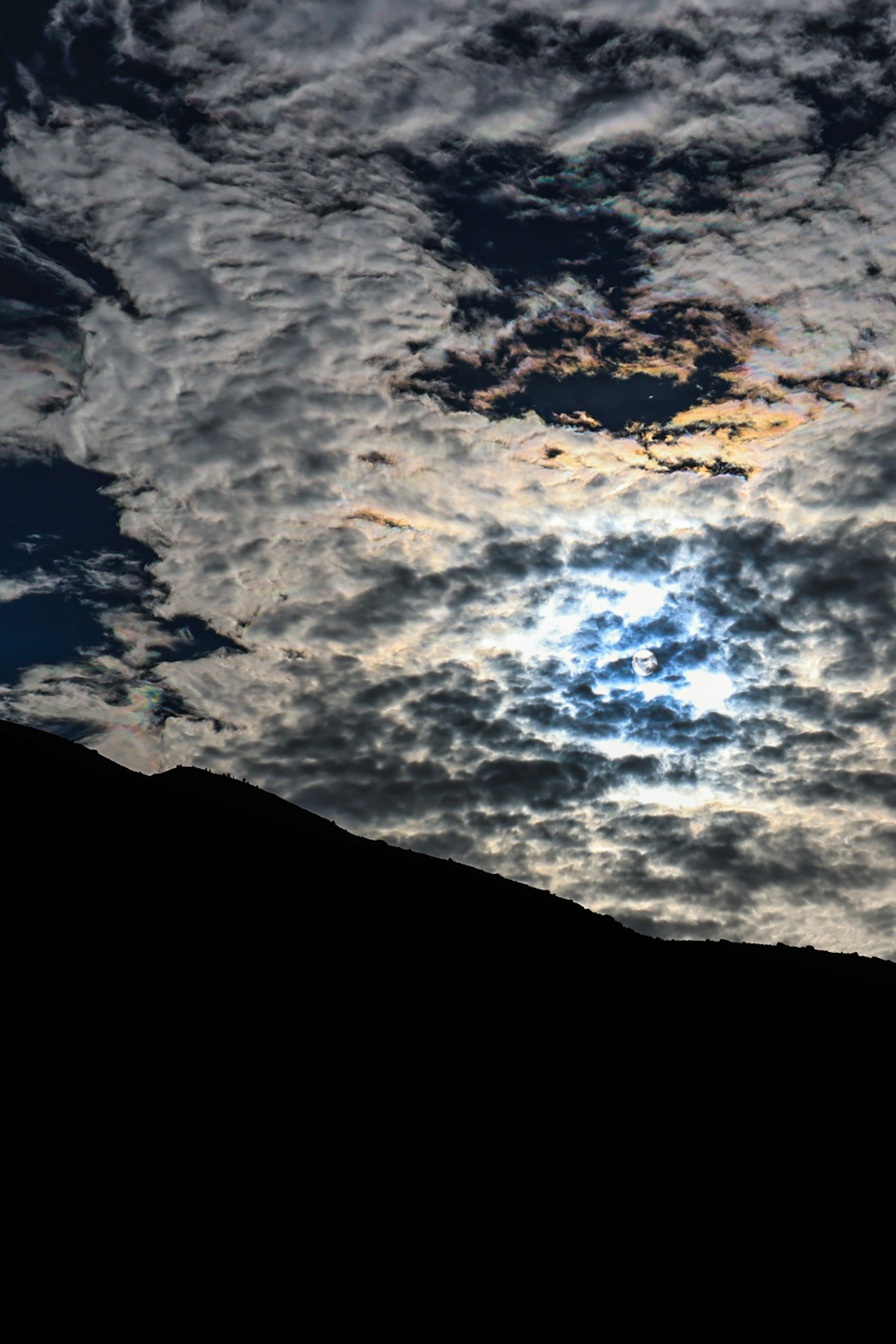 Silhouette d'une montagne sombre contre un ciel nuageux