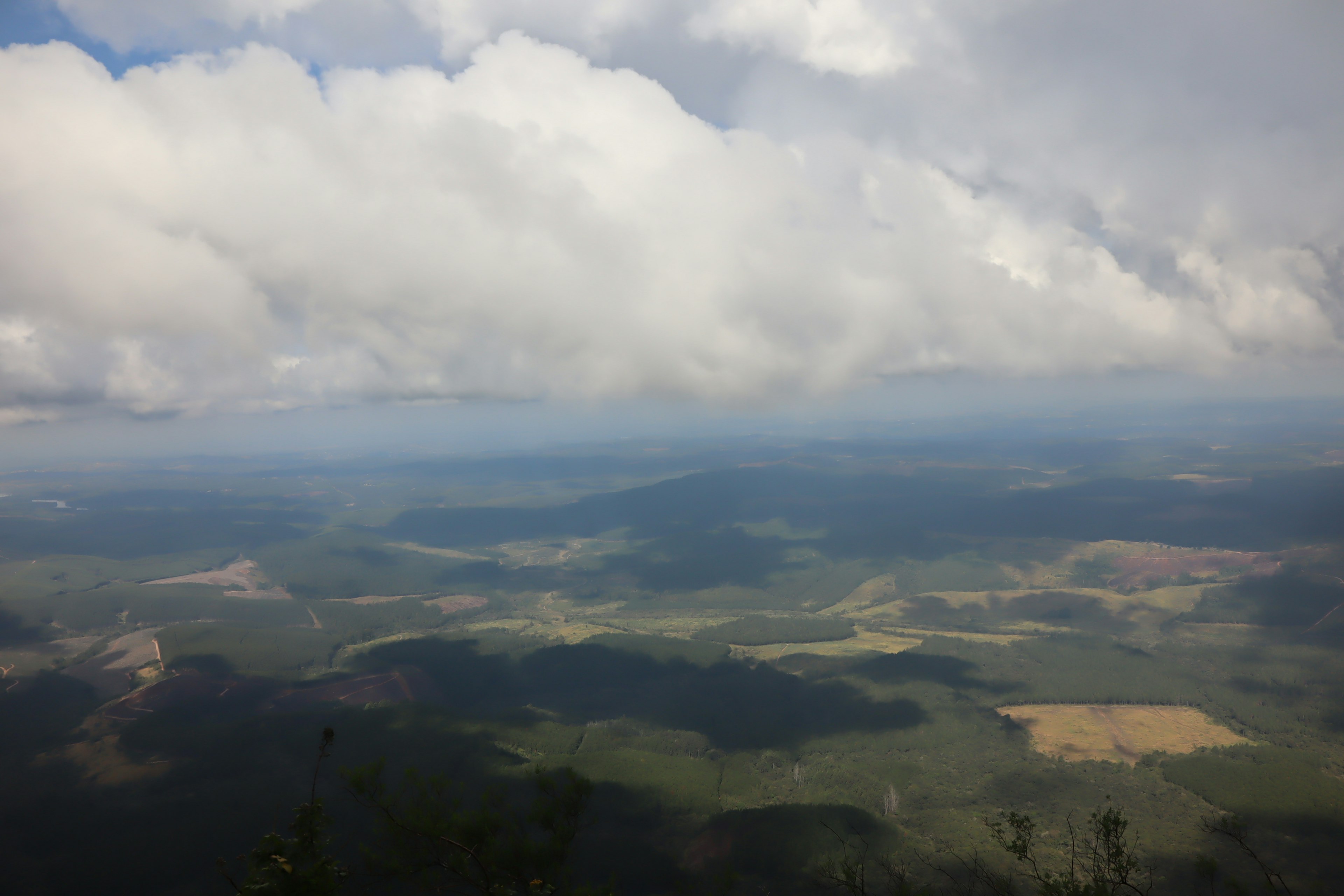 Vast landscape from mountain peak contrasting blue sky and clouds lush green valleys