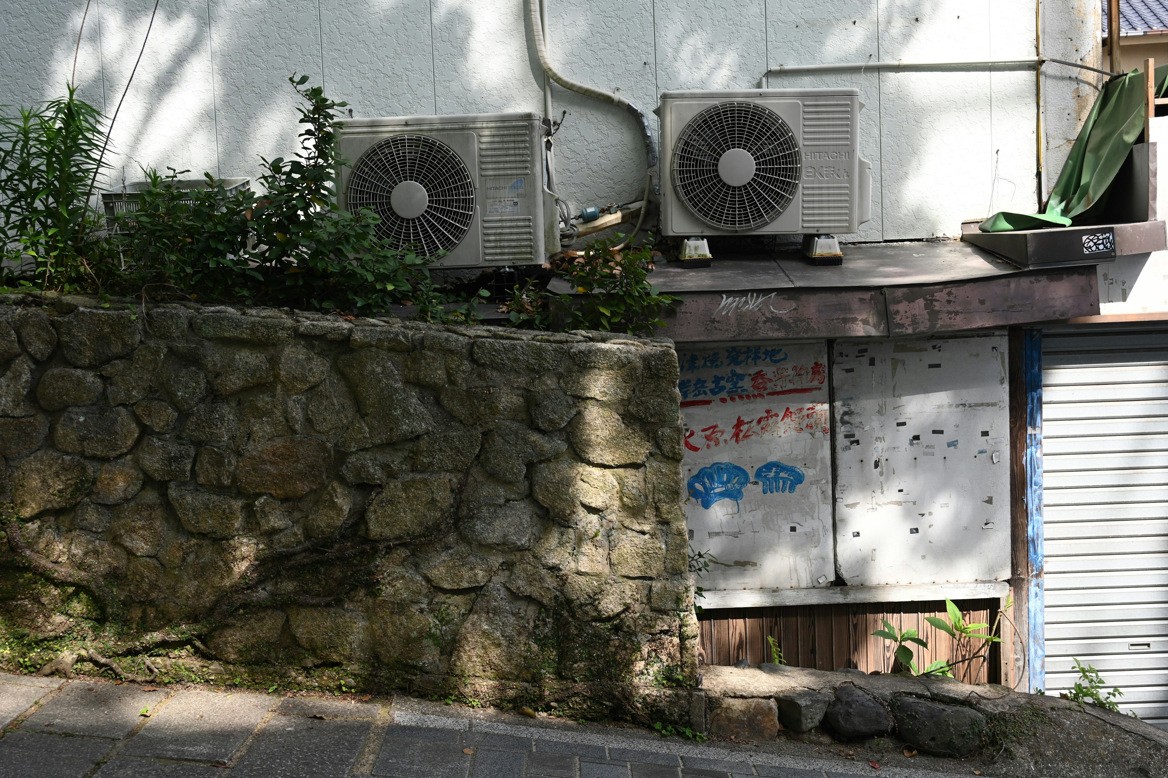 A scene featuring a stone wall and air conditioning units