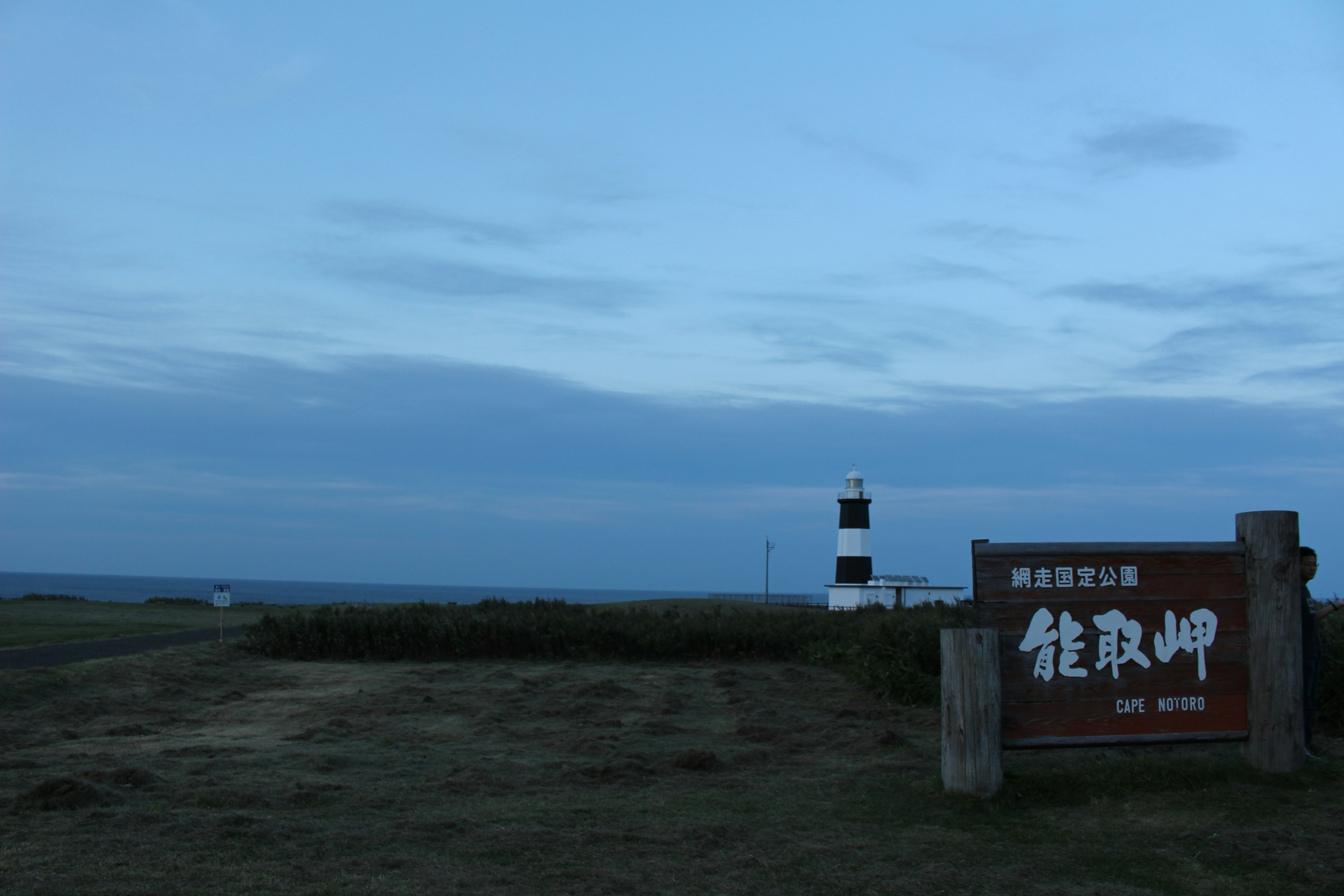 灯台と看板のある海岸の風景