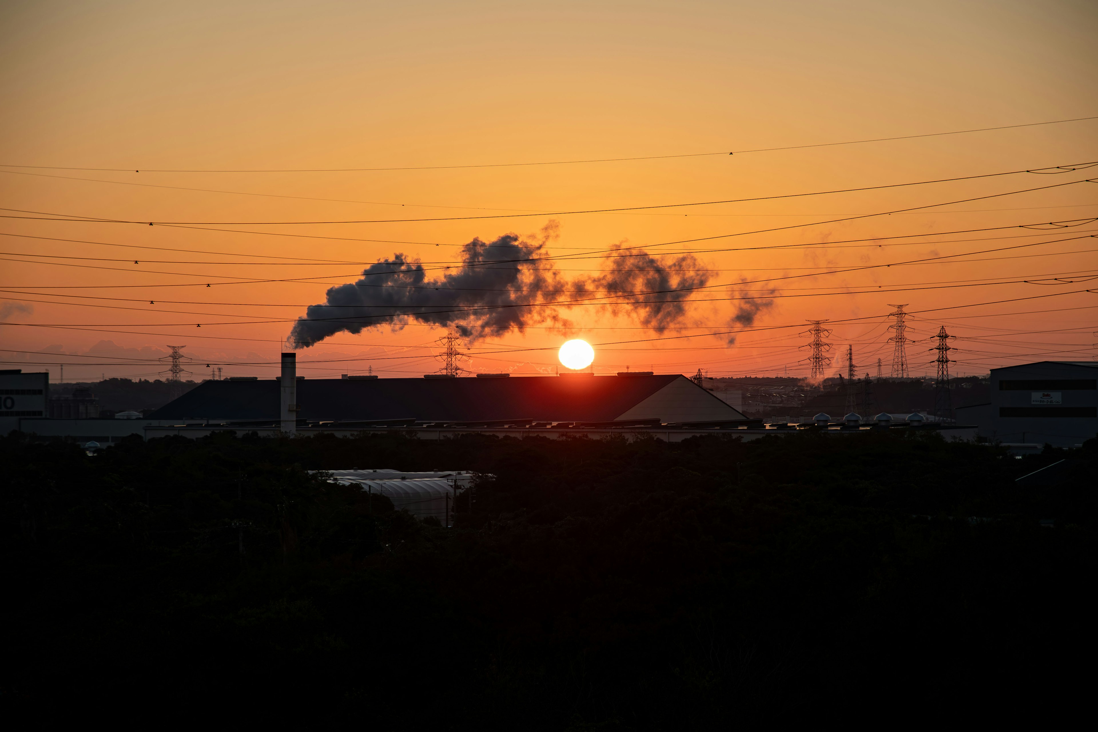 Coucher de soleil avec cheminée industrielle émettant de la fumée