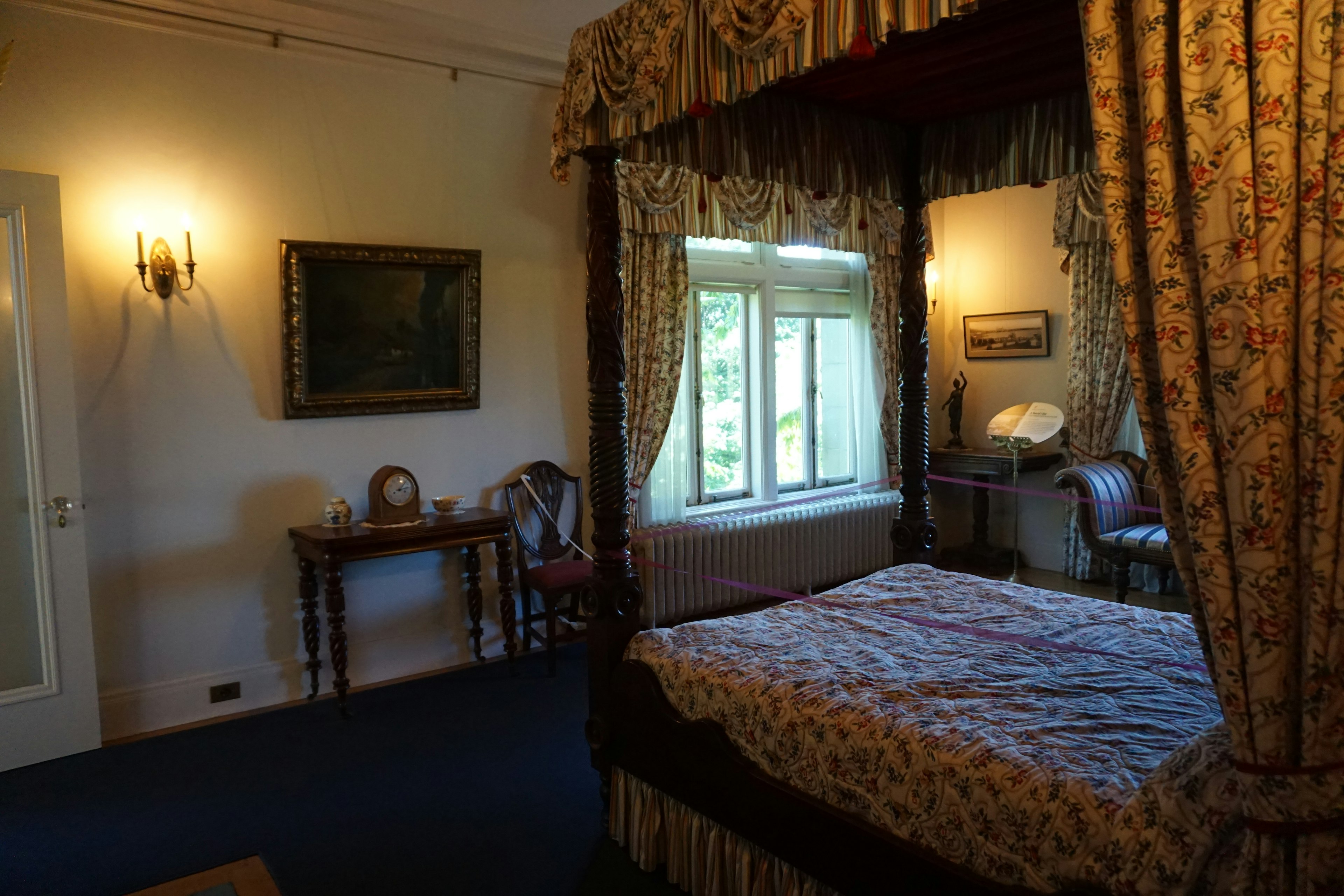 Chambre confortable avec un lit à baldaquin et des rideaux élégants