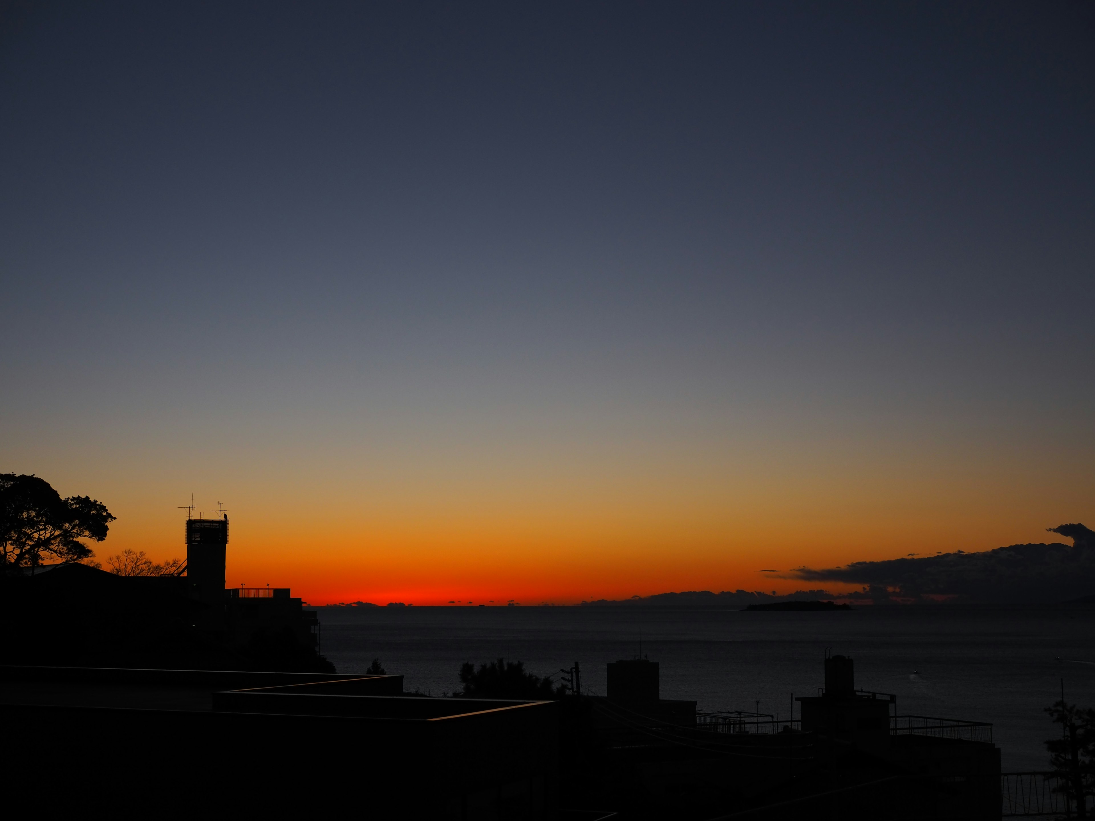 美しい夕焼けが海の水平線に広がるシルエット風景