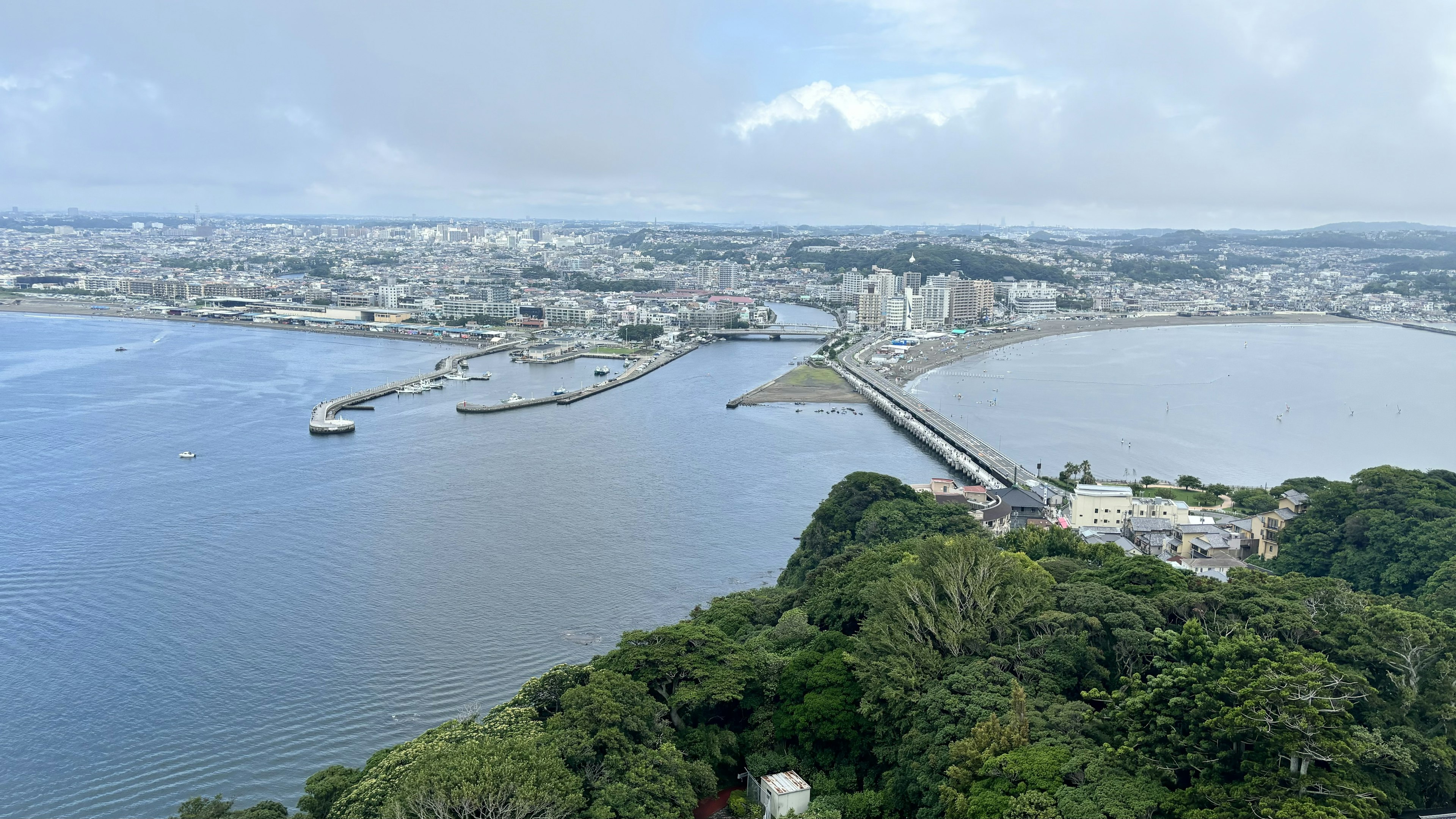 Panoramic view of a coastal city with a bridge and boats