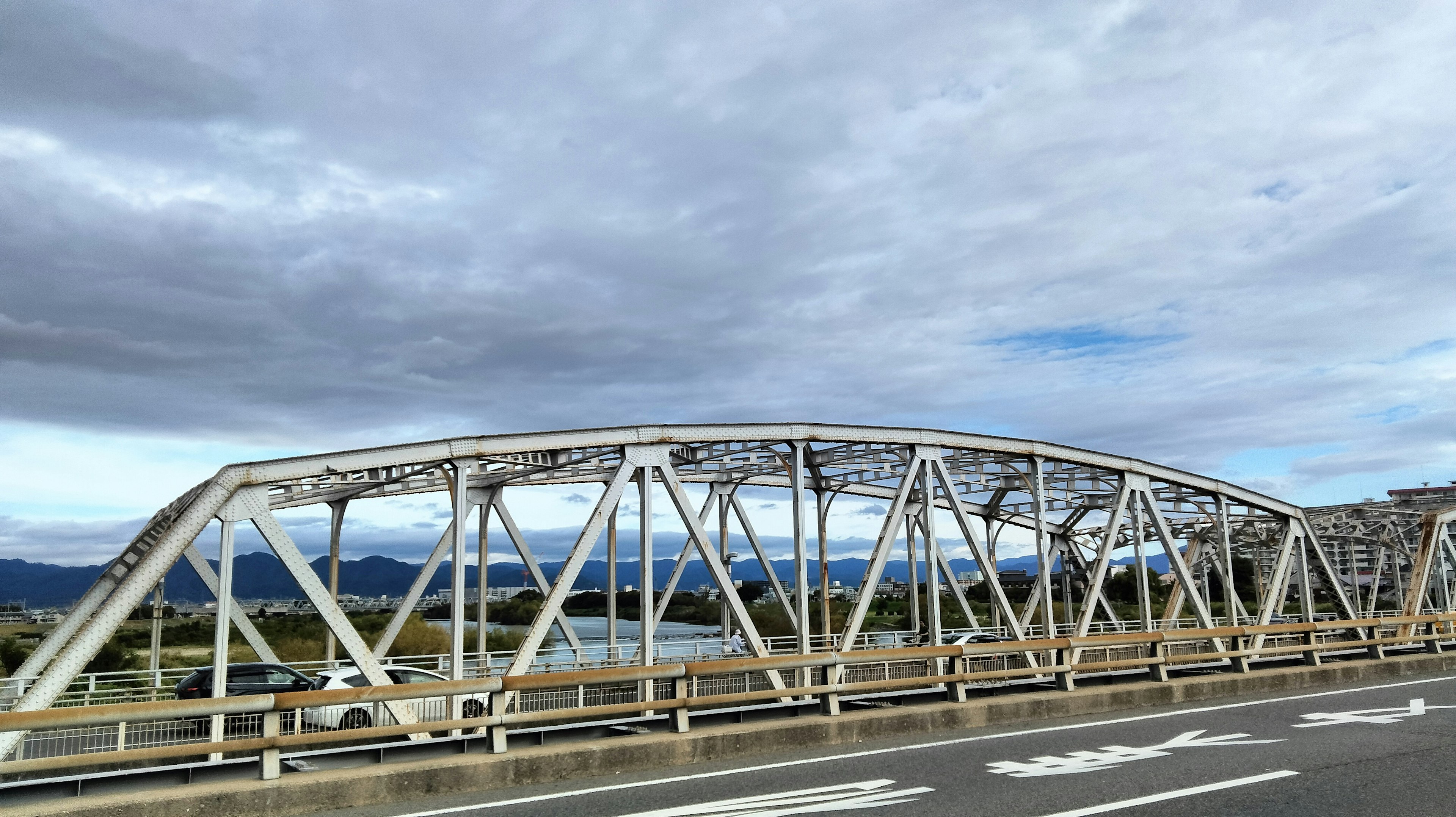 Jembatan lengkung putih membentang di bawah langit biru