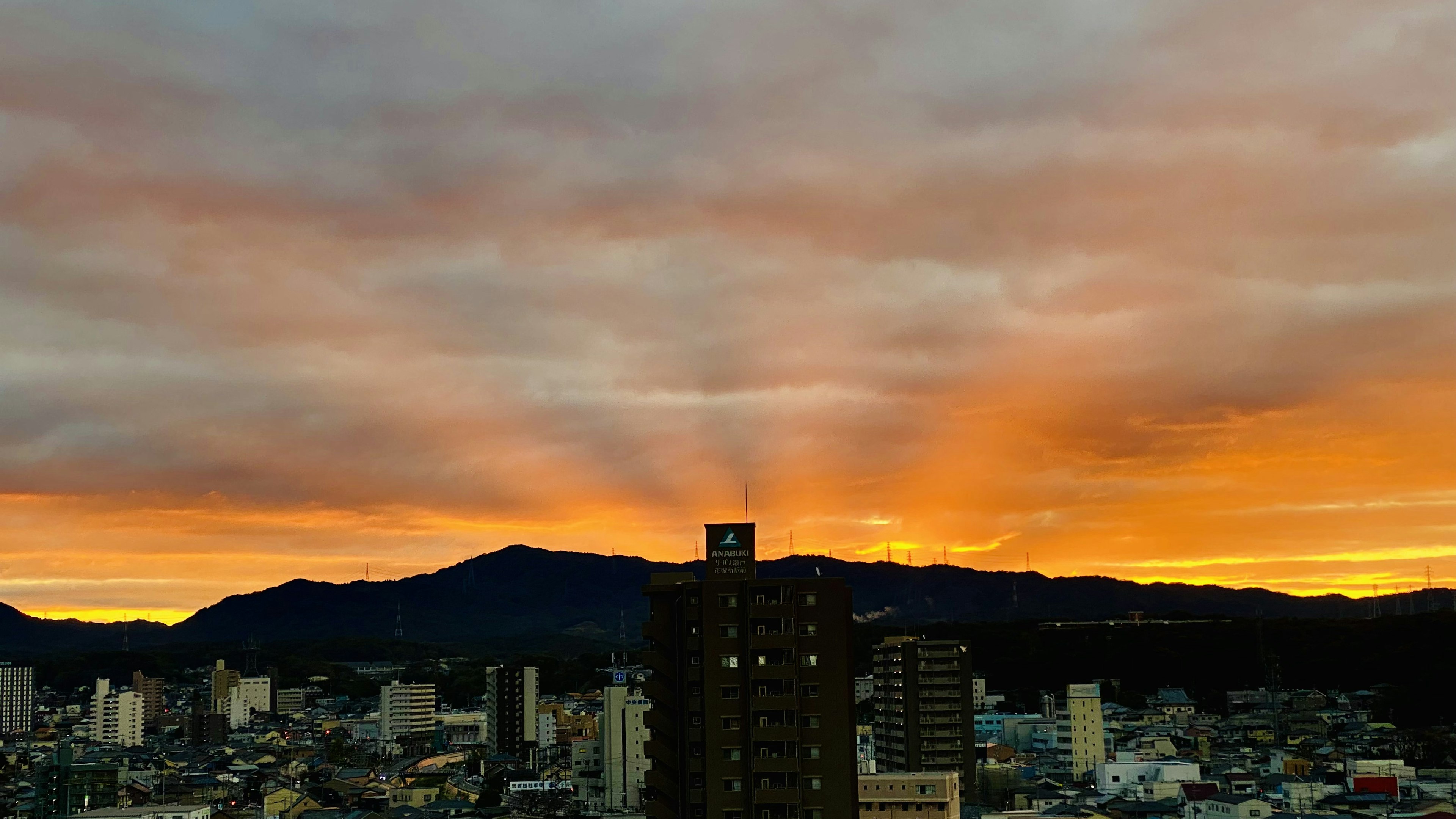 Stadtlandschaft mit Sonnenuntergangshimmel und Bergen im Hintergrund