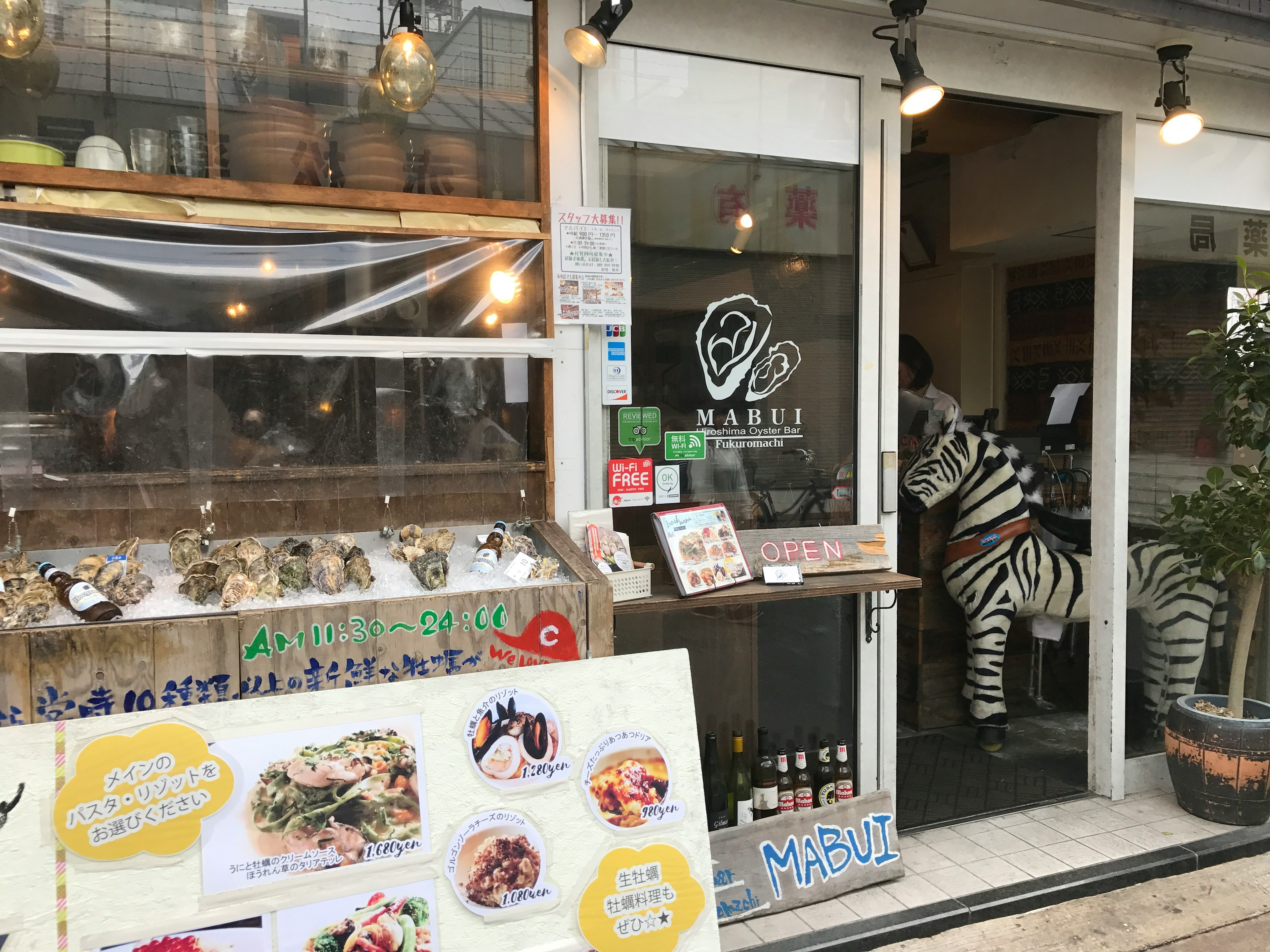 Entrée d'un restaurant avec un panneau de menu et une décoration de zèbre