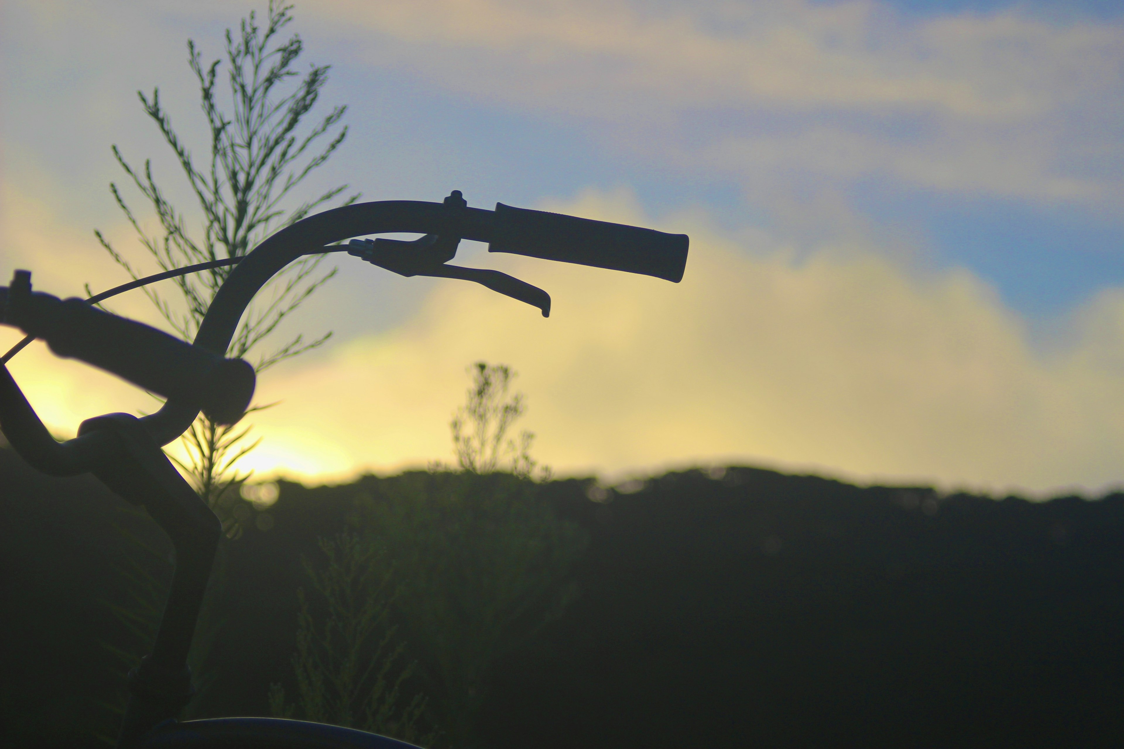 自転車のハンドルのシルエットと夕焼けの背景