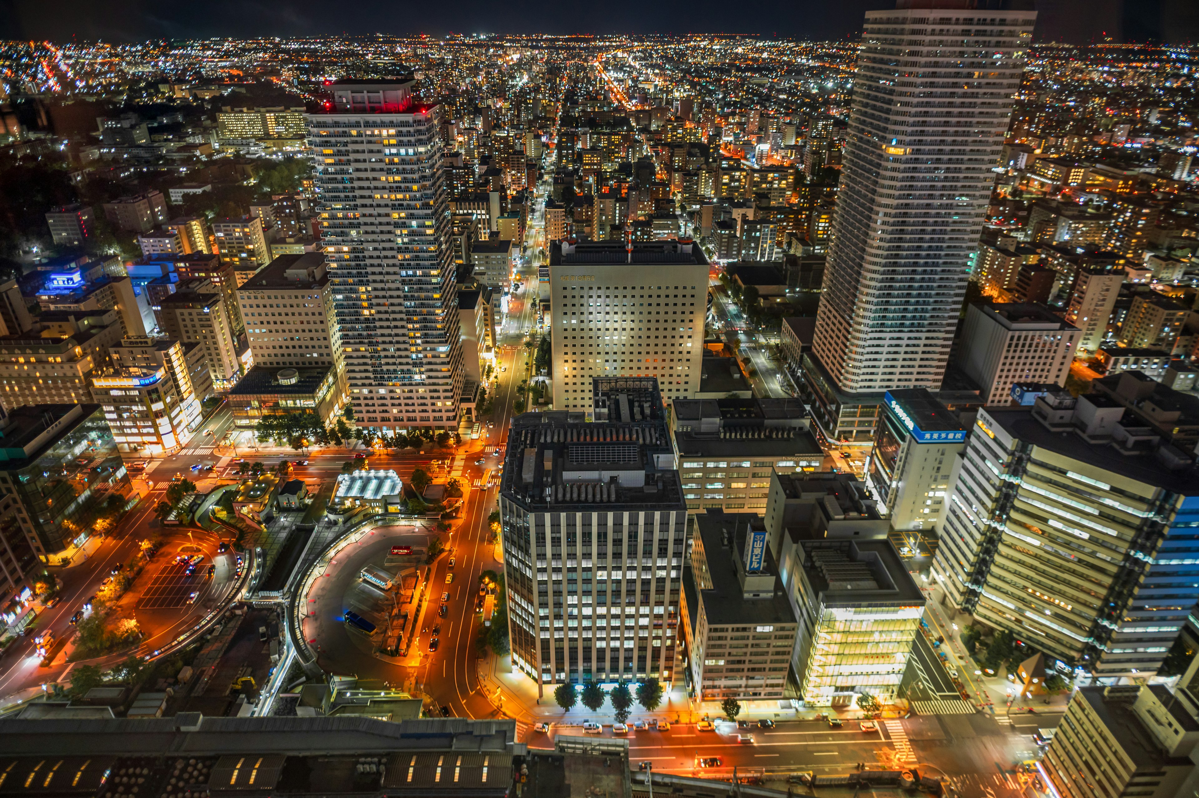 Vista nocturna de un horizonte urbano con rascacielos y luces brillantes en las calles