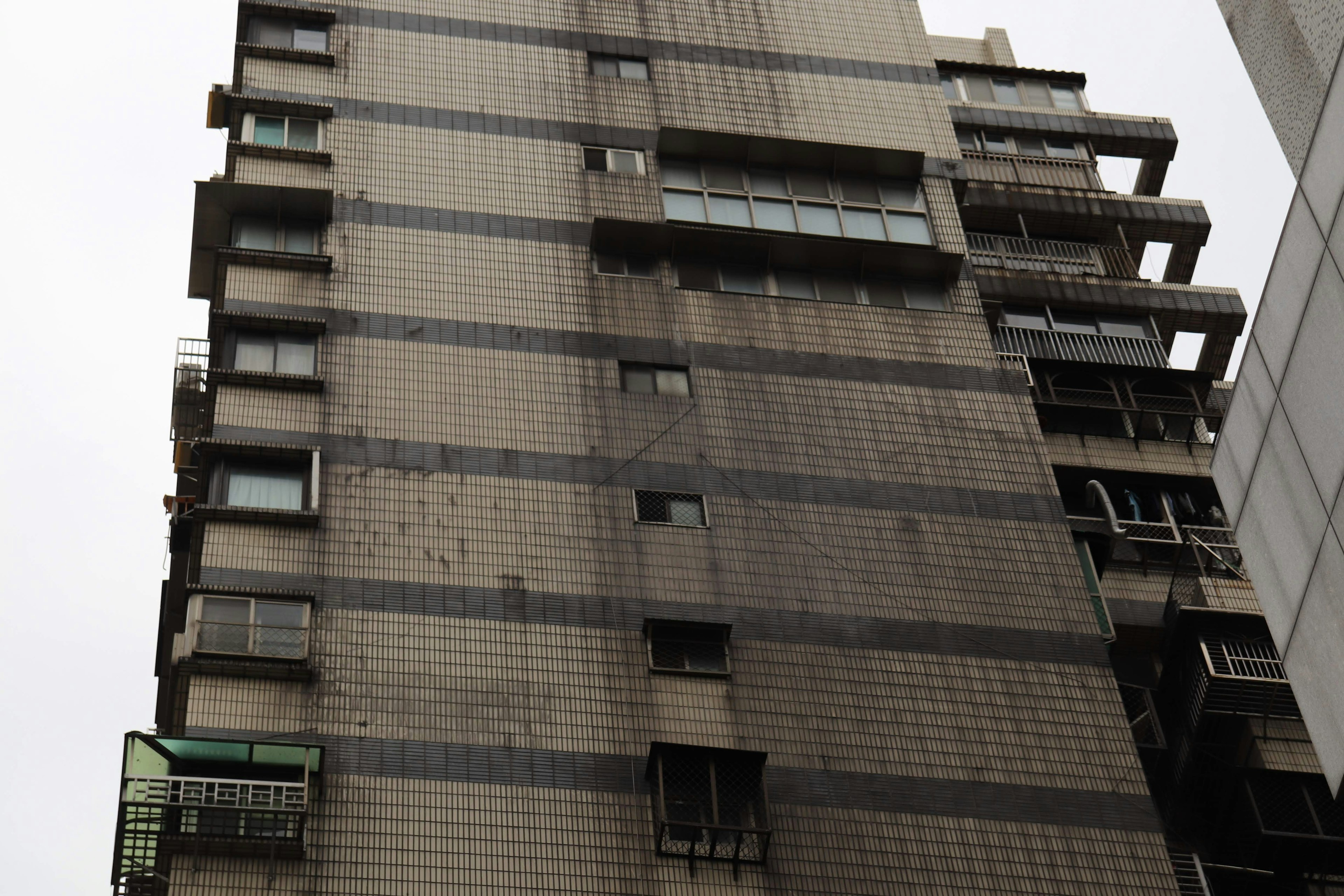 Exterior sucio de un edificio de gran altura con ventanas y balcones visibles