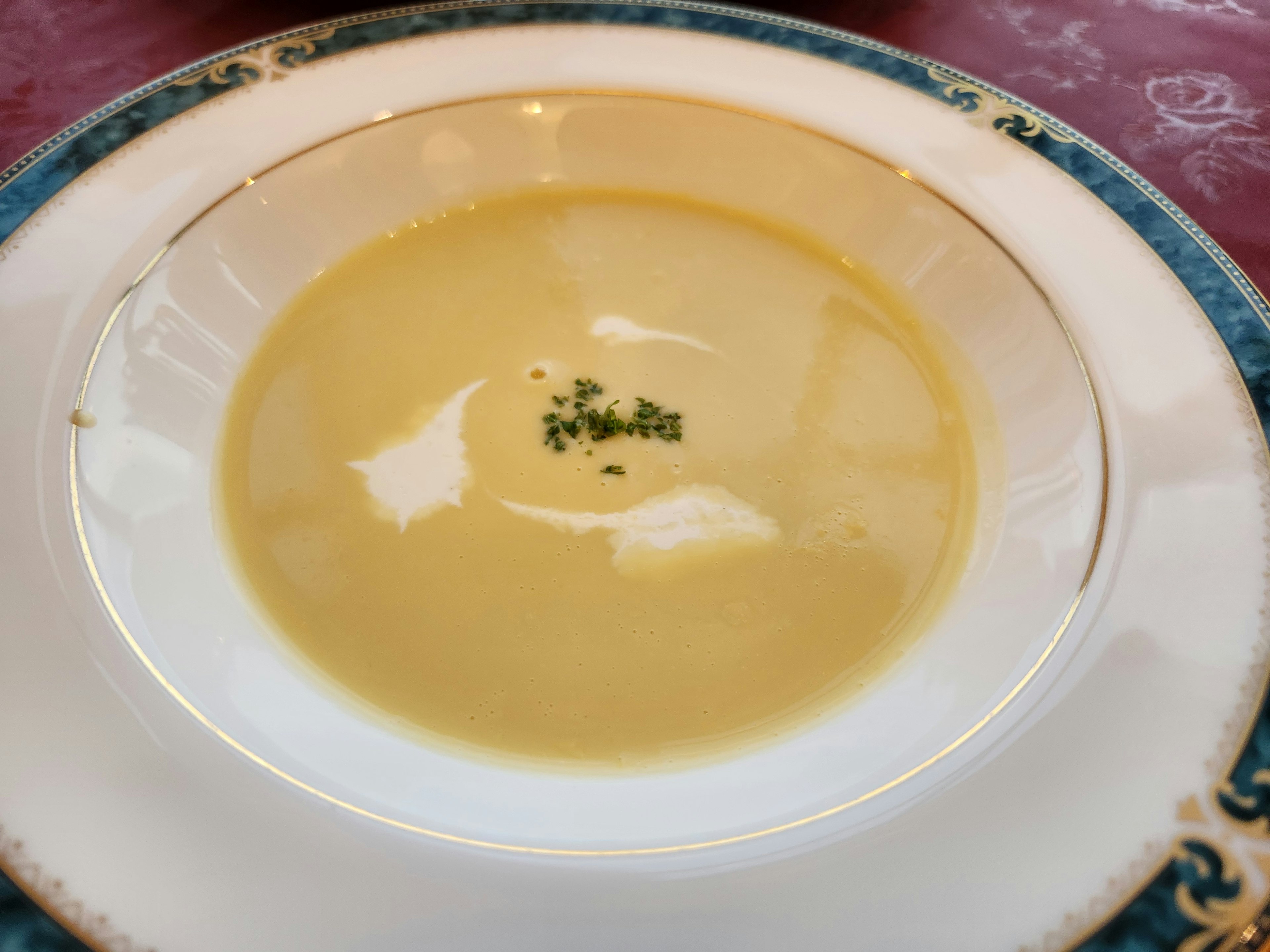 Sopa cremosa servida en un tazón blanco con borde azul