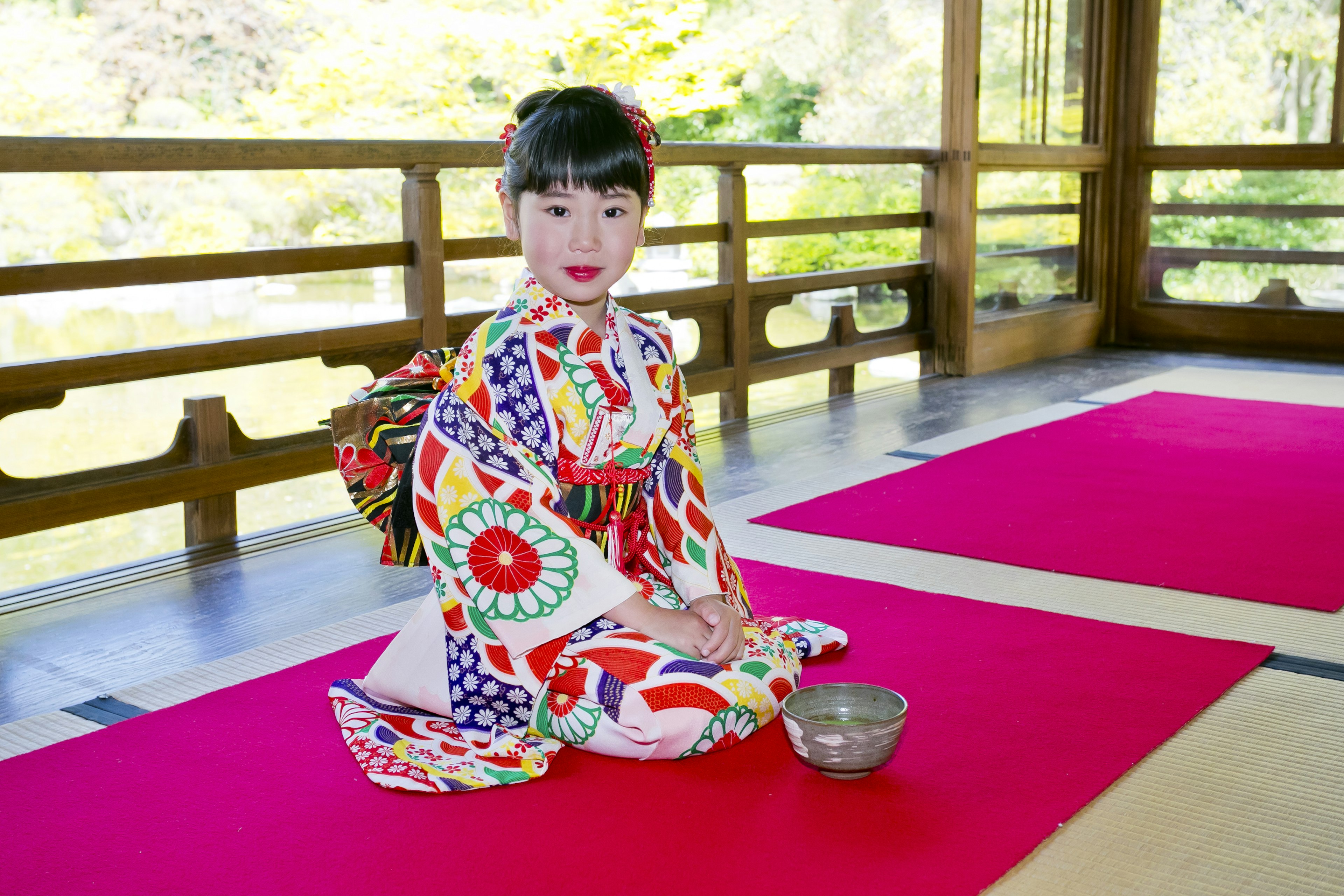 Una niña con un kimono colorido sentada en una habitación japonesa tradicional